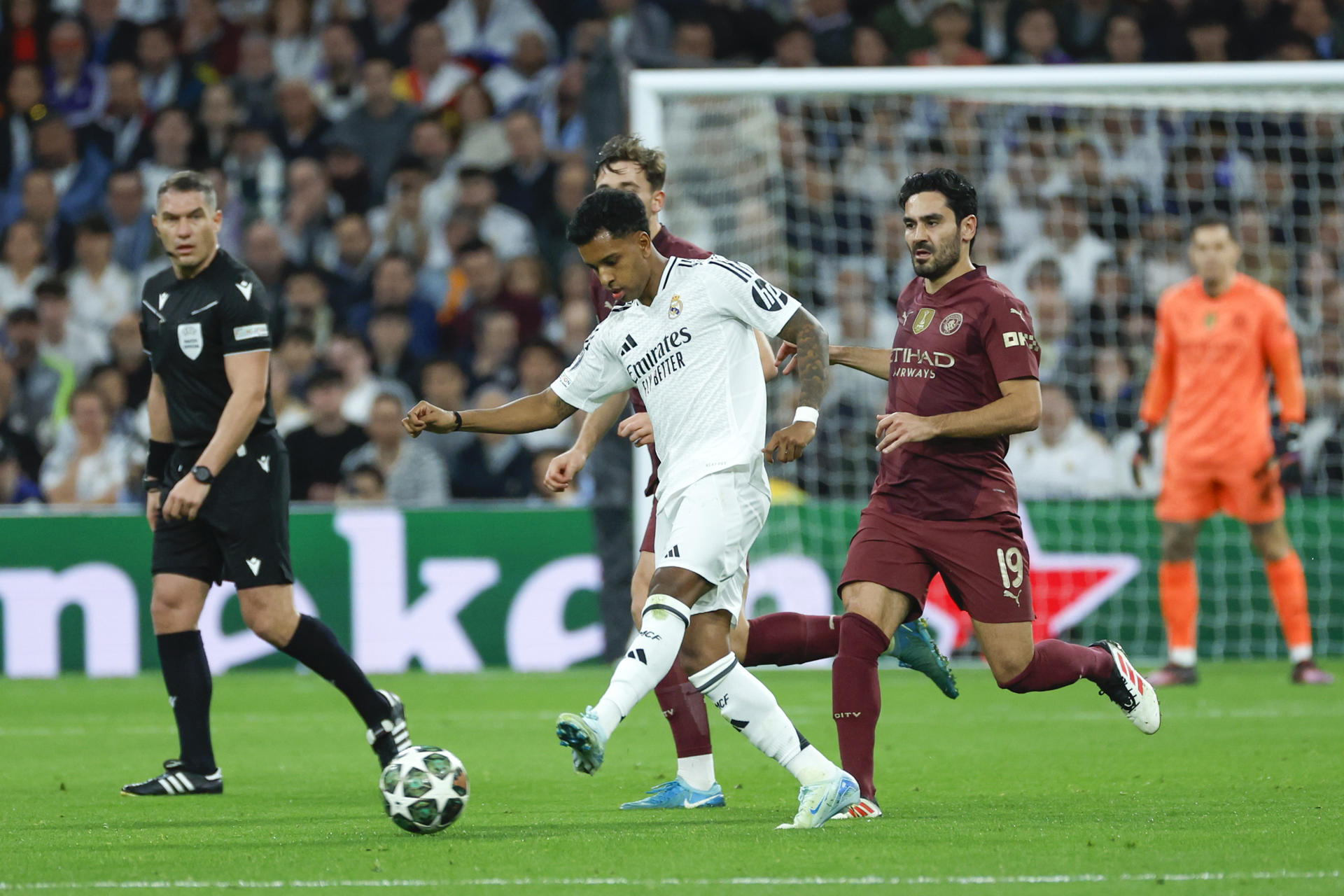 El delantero del Real Madrid Rodrygo Goes (c) centra el balón durante el partido de vuelta de los dieciseisavos de final de la Liga de Campeones que Real Madrid y Manchester City disputan en el estadio Santiago Bernabéu. EFE/Juanjo Martín