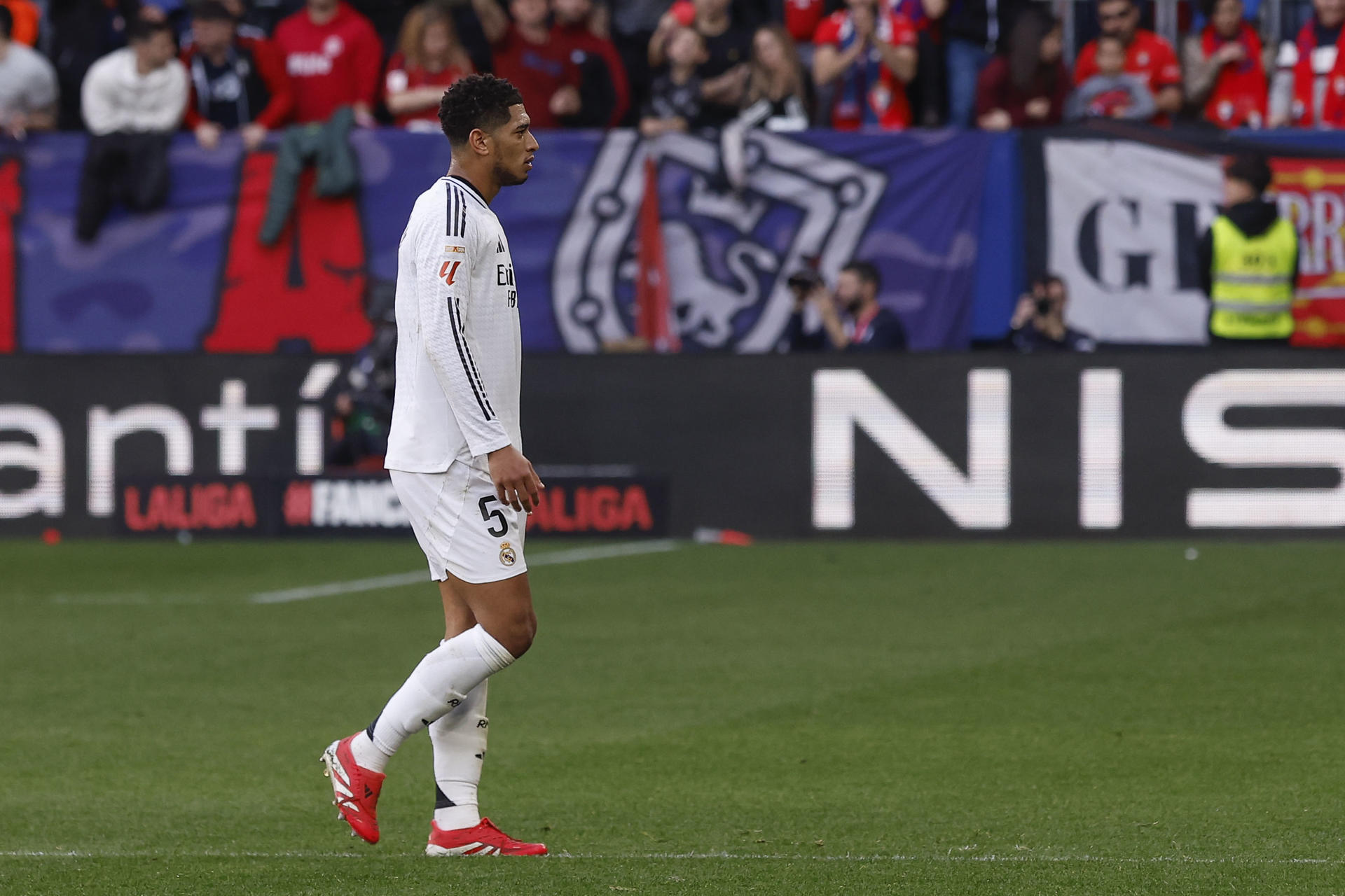 El centrocampista inglés del Real Madrid Jude Bellingham, abandona el terreno de juego expulsado con roja directa, durante el partido de la jornada 24 de la LaLiga EA Sports, disputado este sábado en el estadio el Sadar de Pamplona. EFE/Villar López