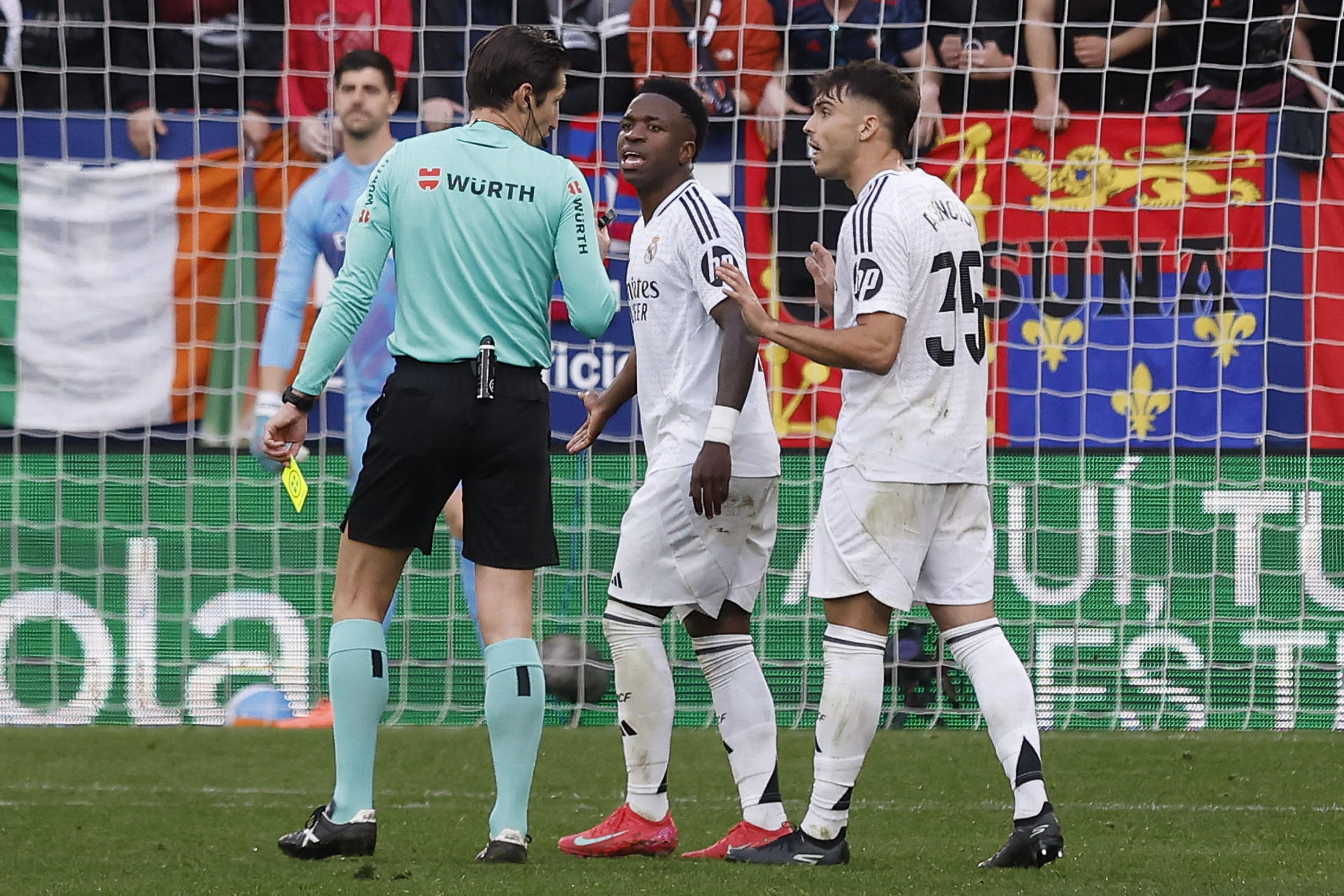 El delantero brasileño del Real Madrid Vinicius Jr conversa con el el colegiado Munuera Montero, durante el partido de la jornada 24 de la LaLiga EA Sports, disputado en el estadio el Sadar de Pamplona. EFE/ Villar López