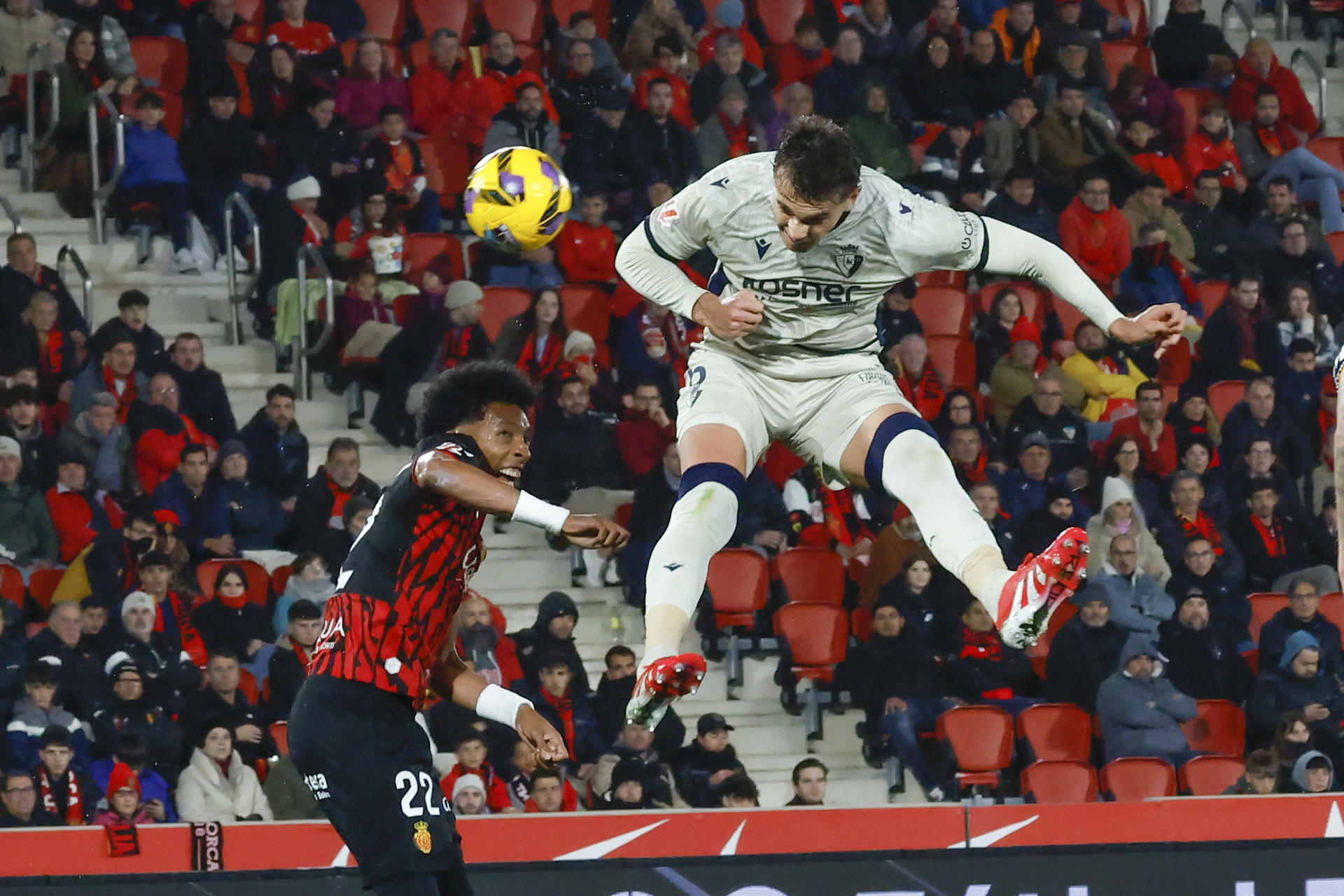 El delantero croata de Osasuna Ante Budimir (d) intenta un remate en el partido de LaLiga entre el Mallorca y el Osasuna, este lunes en el estadio de Son Moix, en Palma. EFE/CATI CLADERA