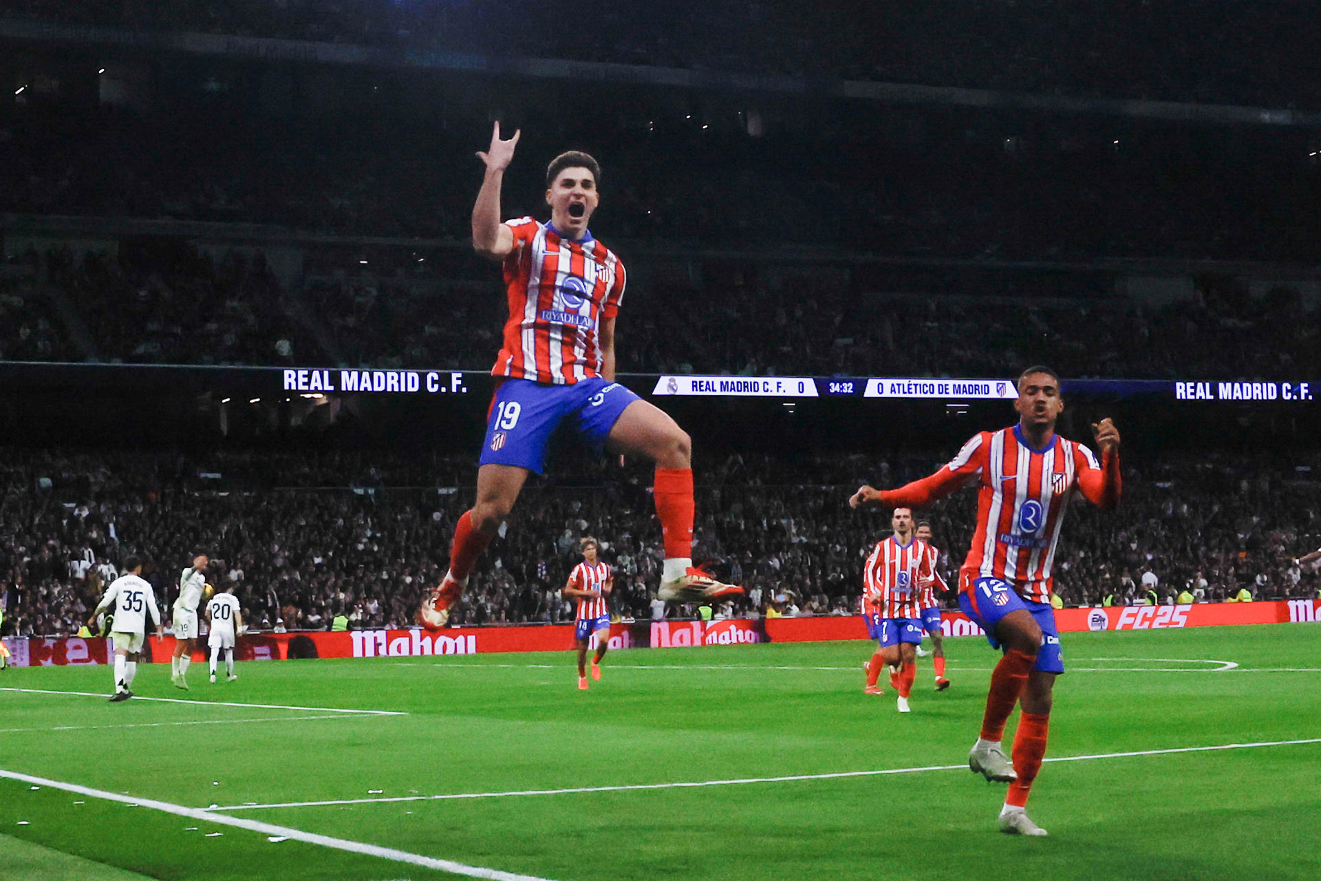 El delantero del Atlético Julián Álvarez (i) celebra tras marcar ante el Real Madrid, durante el partido de LaLiga de fútbol que Real Madrid y Atlético de Madrid disputan en el estadio Santiago Bernabéu. EFE/Juanjo Martín