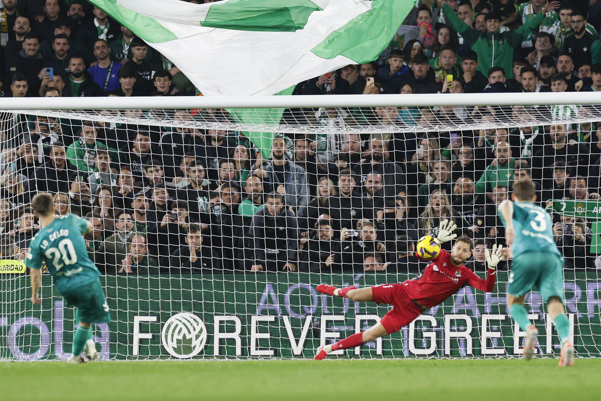 El portero de la Real Sociedad Alejandro Remiro para el penalti lanzado por el centrocampista del Betis Giovani Lo Celso, durante el partido de la jornada 24 de LaLiga que Real Betis y Real Sociedad disputan hoy domingo en el estadio Benito Villamarín. EFE/ Julio Munoz