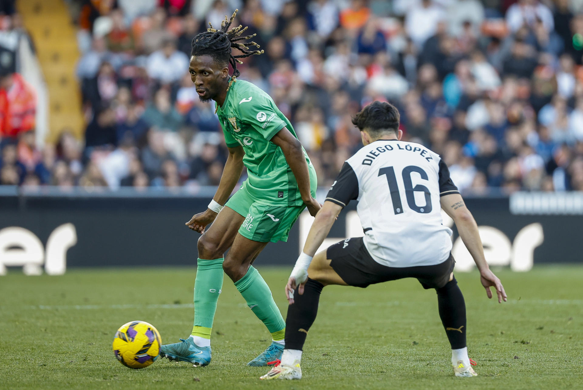 El centrocampista camerunés del Leganés Yvan Neyou (i) con el balón ante Diego López, del Valencia, durante el partido de LaLiga disputado entre el Valencia y el Leganés en el estadio de Mestalla. EFE/Ana Escobar