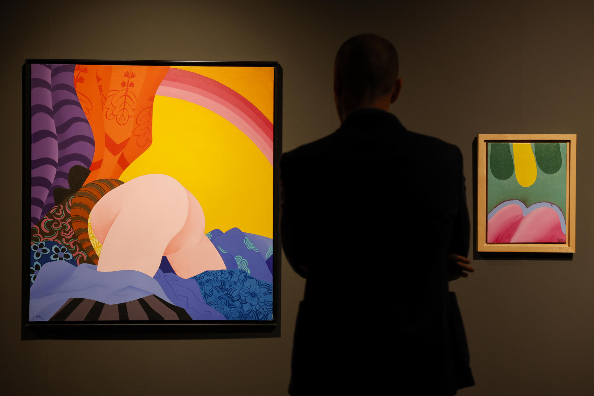 Una persona recorre la exposición "Un viajero cosmopolita", que recorre cuarenta años de trayectoria de Eduardo Úrculo, referente del pop art, desde la abstracción y lenguaje expresionista de sus primeras obras, la explosión de color y deseo que marcan su época pop, y una última etapa centrada en el tránsito, la contemplación y el gran viaje de la vida con sus icónicas obras llenas de sombreros, maletas y paraguas. EFE/Ana Escobar