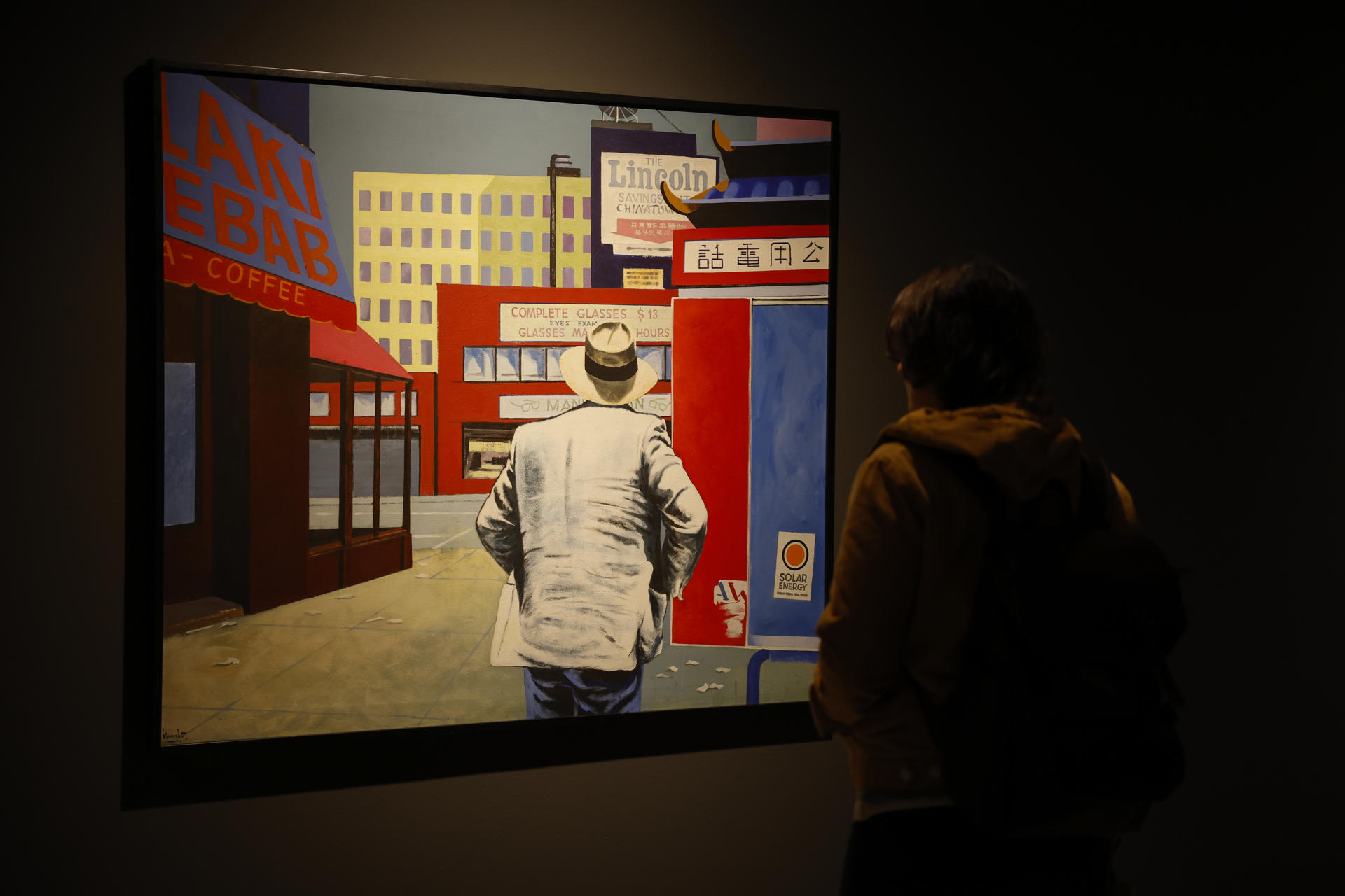 Una persona recorre la exposición "Un viajero cosmopolita", que recorre cuarenta años de trayectoria de Eduardo Úrculo, referente del pop art, desde la abstracción y lenguaje expresionista de sus primeras obras, la explosión de color y deseo que marcan su época pop, y una última etapa centrada en el tránsito, la contemplación y el gran viaje de la vida con sus icónicas obras llenas de sombreros, maletas y paraguas. EFE/Ana Escobar
