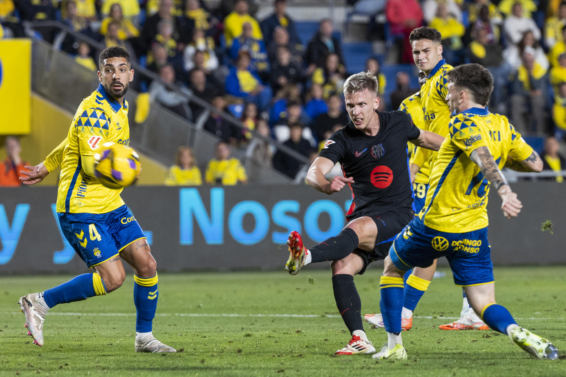 El centrocampista del FC Barcelona, Dani Olmo (c), remata ante los defensores en la jugada que ha significado el primer gol de su equipo durante el encuentro correspondiente a la jornada 25 de Laliga EA Sports que disputaron en el estadio de Gran Canaria. EFE / Quique Curbelo.