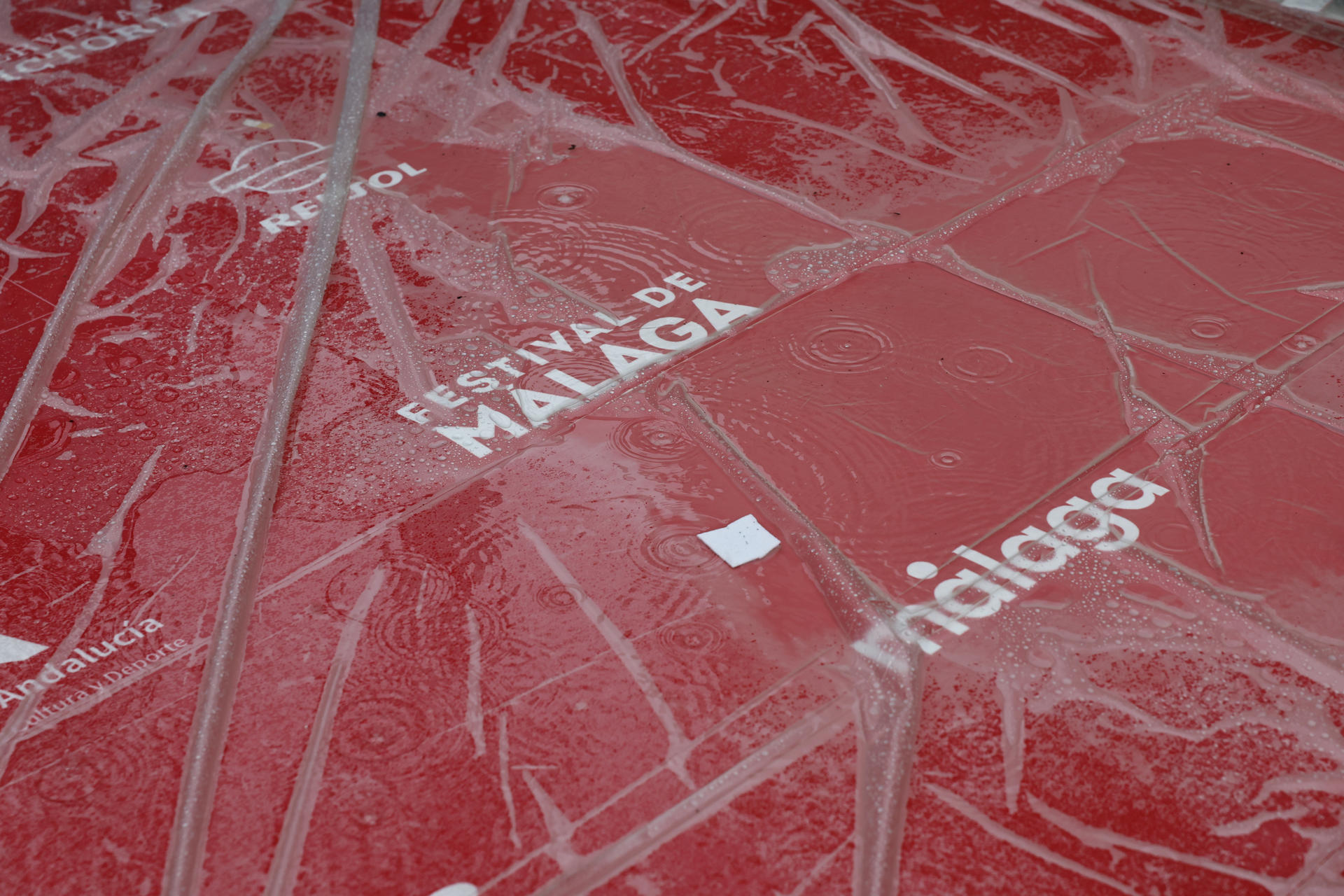 Detalle de la alfombra roja colocada para la inauguración de la XXVIII edición del Festival de Cine en Español de Málaga, cubierta con plástico por la lluvia que no cesa, que se celebrará este viernes en el Teatro Cervantes de la capital y que contará en su sección oficial a concurso con quince largometrajes españoles y siete iberoamericanos y rendirá homenaje, entre otras figuras, a la actriz Carmen Machi, que recibirá el Premio Málaga, este jueves en la capital malagueña.EFE/Jorge Zapata