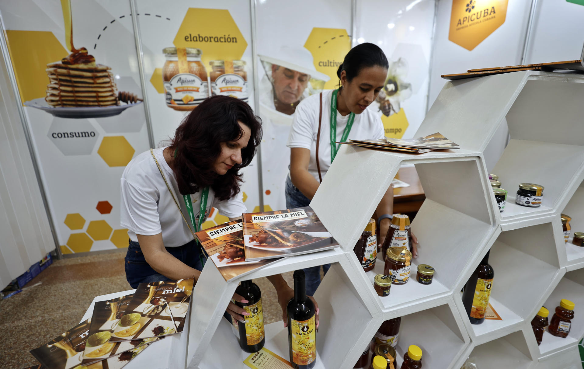 Fotografía del 17 de marzo de 2025 de dos mujeres organizando sus productos para la venta en una feria en La Habana (Cuba). EFE/ Ernesto Mastrascusa
