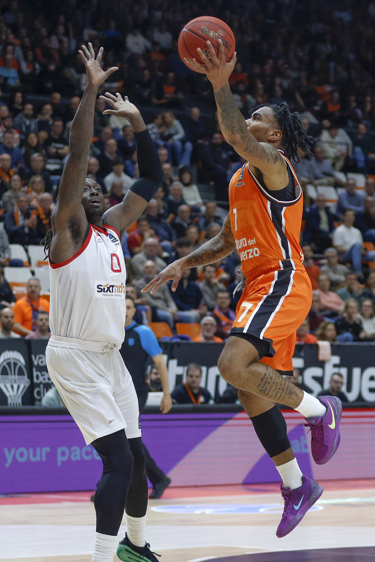 El base armenio del Valencia Chris Jones (d) en acción ante el alero estadounidense del Hapoel Tel Aviv Johnathan Motley, durante el partido de semifinales de la Eurocopa de baloncesto que Valencia Basket y Hapoel Tel Aviv disputaron en la Fuente de San Luis, en Valencia. EFE/Miguel Ángel Polo