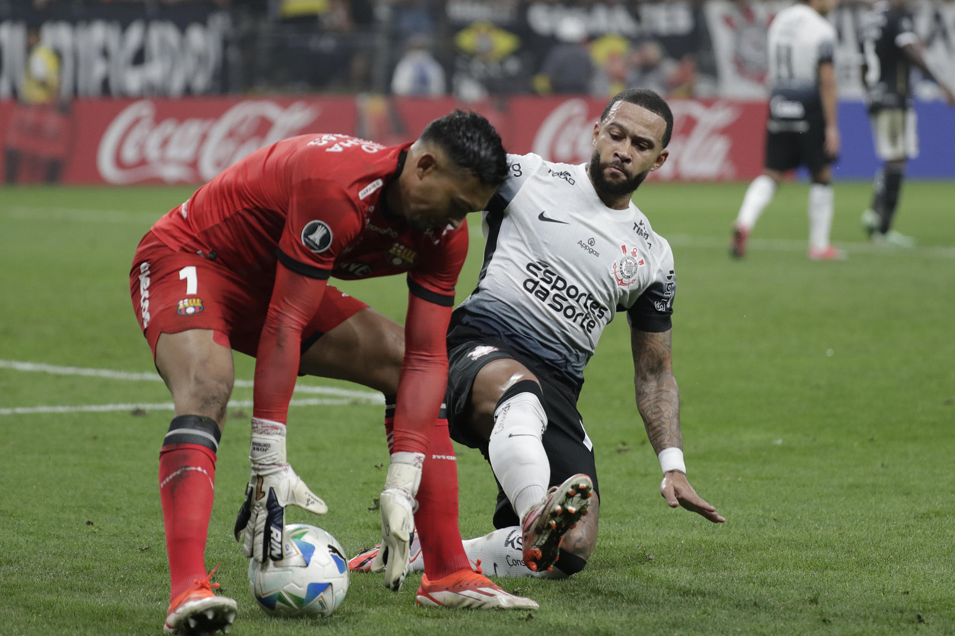 Memphis Depay (d) de Corinthians disputa el balón con Jesús David Contreras de Barcelona. EFE/ Sebastiao Moreira