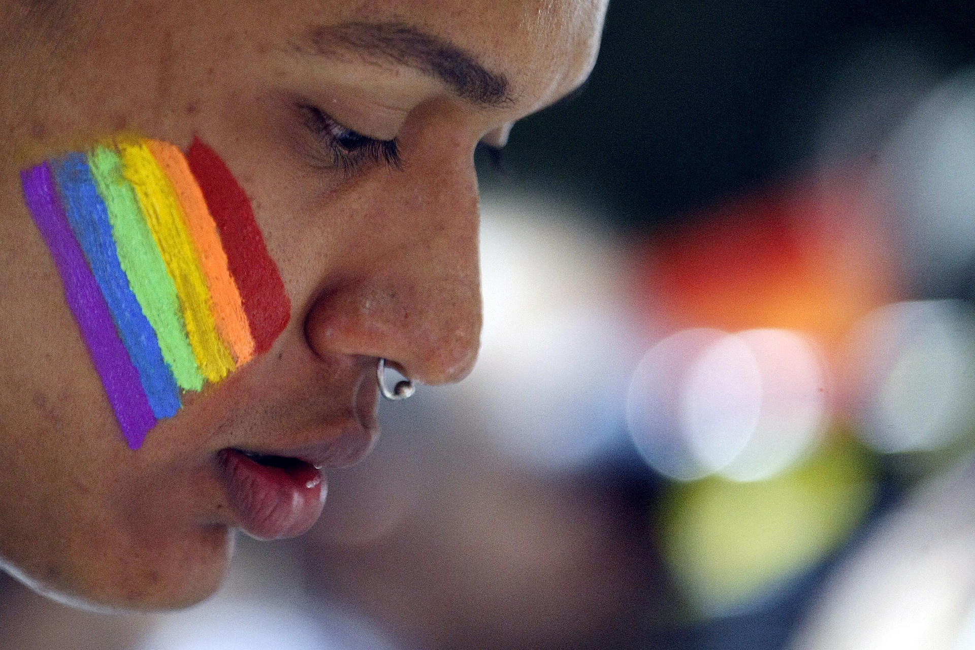 Fotografía de archivo en donde se ve a un joven con una bandera LGTBIQ+ en su mejilla. EFE/Christian Escobar Mora