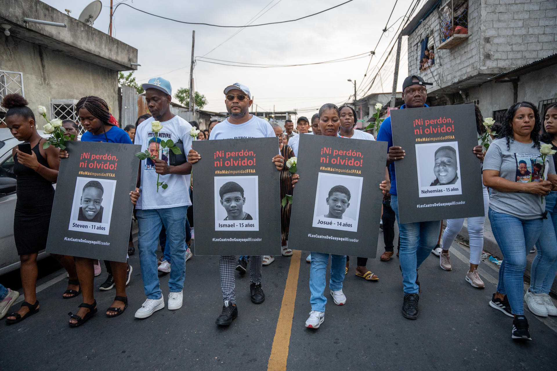 Personas sostienen carteles con las imágenes de los cuatro niños desaparecidos, durante una manifestación en el barrio Las Malvinas, al sur de la ciudad de Guayaquil (Ecuador). Foto de archivo. EFE/ Mauricio Torres