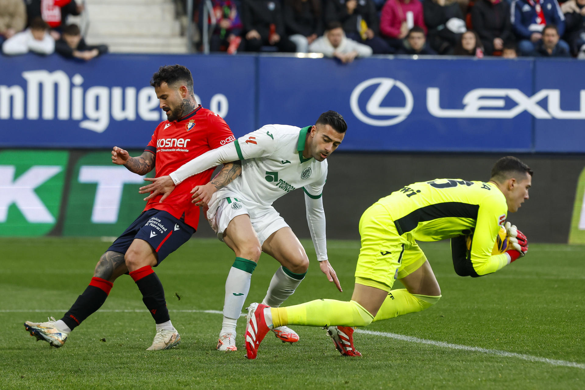 El guardameta del Getafe, David Soria (d), atrapa el balón durante el encuentro correspondiente a la jornada 28 de Laliga EA Sports en el estadio El Sadar, en Pamplona. EFE / Villar López.