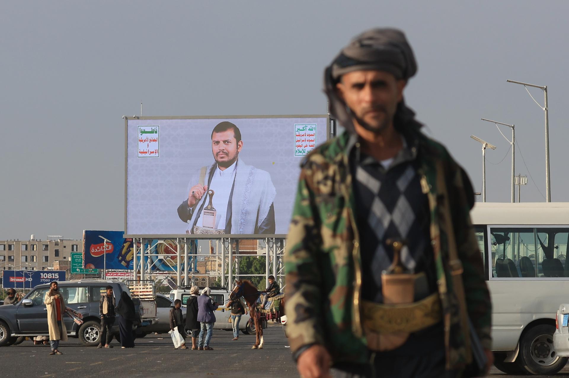 Las personas pasan junto a una valla publicitaria digital con la imagen del líder de los hutíes, Abdul-Malik al-Houthi, en Saná, Yemen, . Los hutíes de Yemen han condenado la reanudación de los ataques de Israel contra la Franja de Gaza, prometiendo intensificar sus operaciones militares contra Israel hasta que su guerra en Gaza se detenga, dijo el Buró Político de los hutíes en un comunicado. EFE/EPA/YAHYA ARHAB