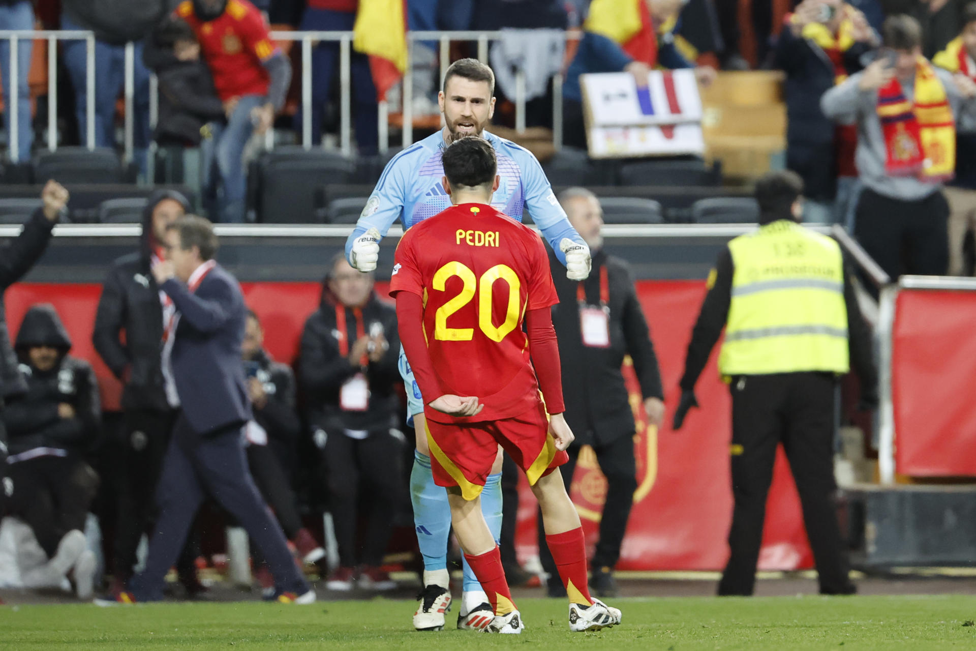 El centrocampista de la selección española Pedri (20) celebra con el portero Unai Simón la victoria ante Países Bajos, al término del partido de vuelta de los cuartos de final de la Liga de Naciones que las selecciones de España y Países Bajos han disputado este domingo en el estadio de Mestalla, en Valencia. EFE/Ana Escolar