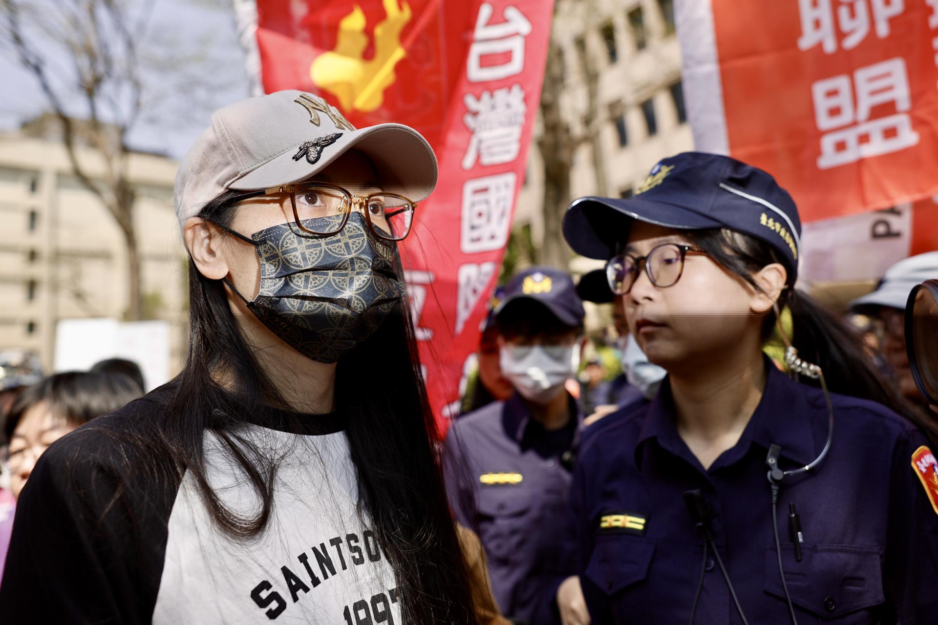 La ciudadana china e'influencer' Liu (I) es escoltada por oficiales de policía taiwaneses después de su conferencia de prensa en Taipei, el 25 de marzo de 2025.