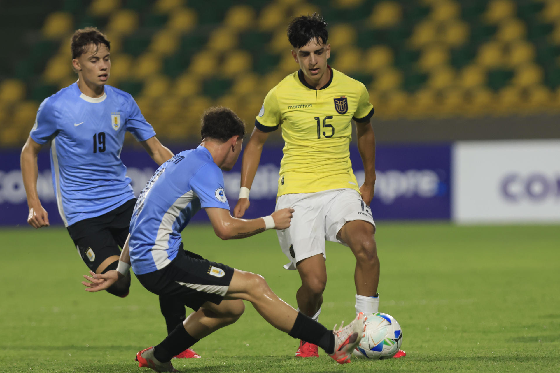El ecuatoriano Yaxi Johan García avanza con el balón ante la marca de dos rivales uruguayos este domingo durante el partido del Grupo B del Campeonato Sudamericano sub-17 que la Tri ganó por 0-4 a la Celeste en el estadio Olímpico Jaime Morón León, en la ciudad colombiana de Cartagena. EFE/ Ricardo Maldonado