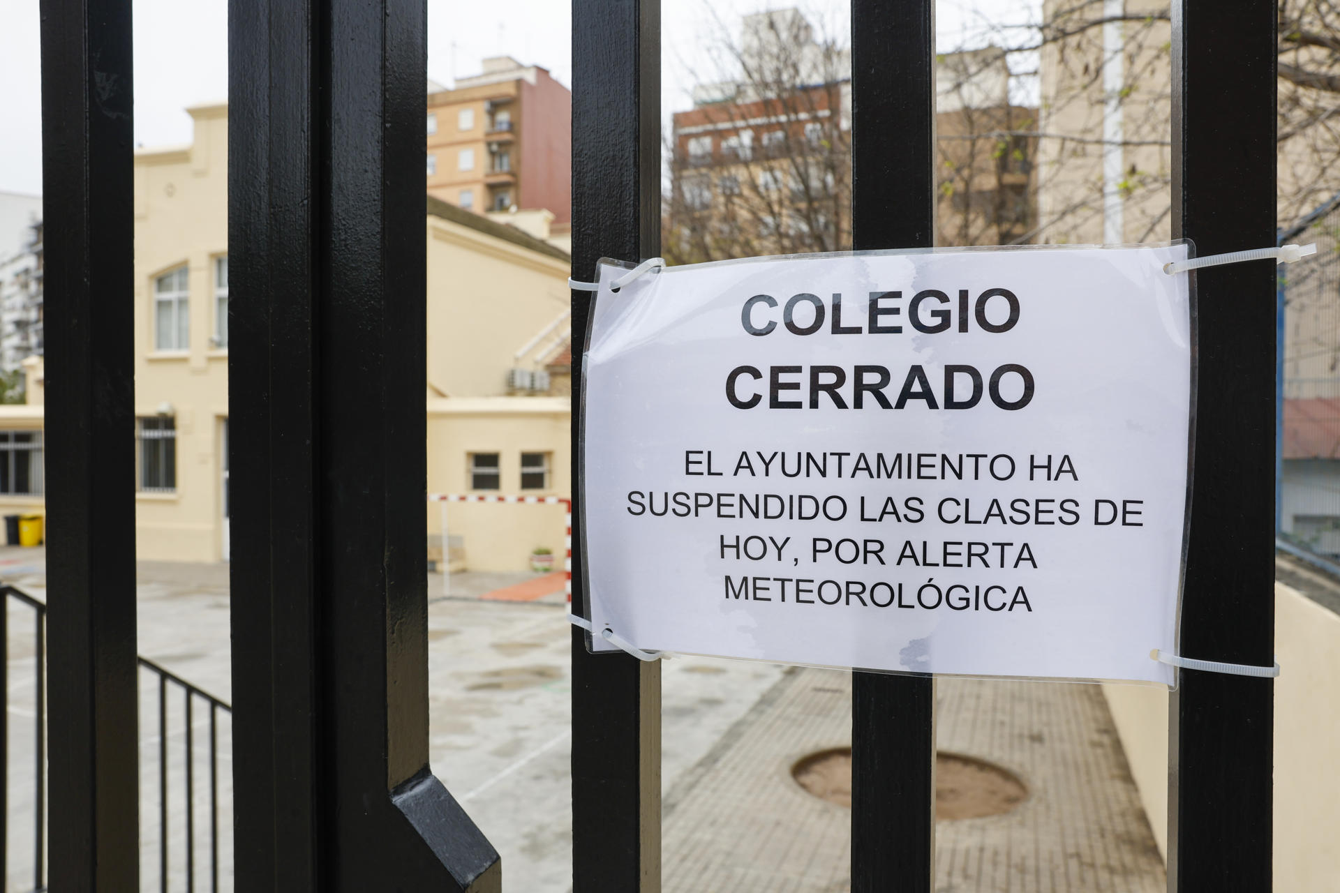 Detalle de un cartel en la puerta de un colegio que anuncia la suspensión de clases durante este jueves ante la alerta meteorológica naranja en la ciudad de València. EFE/Ana Escobar