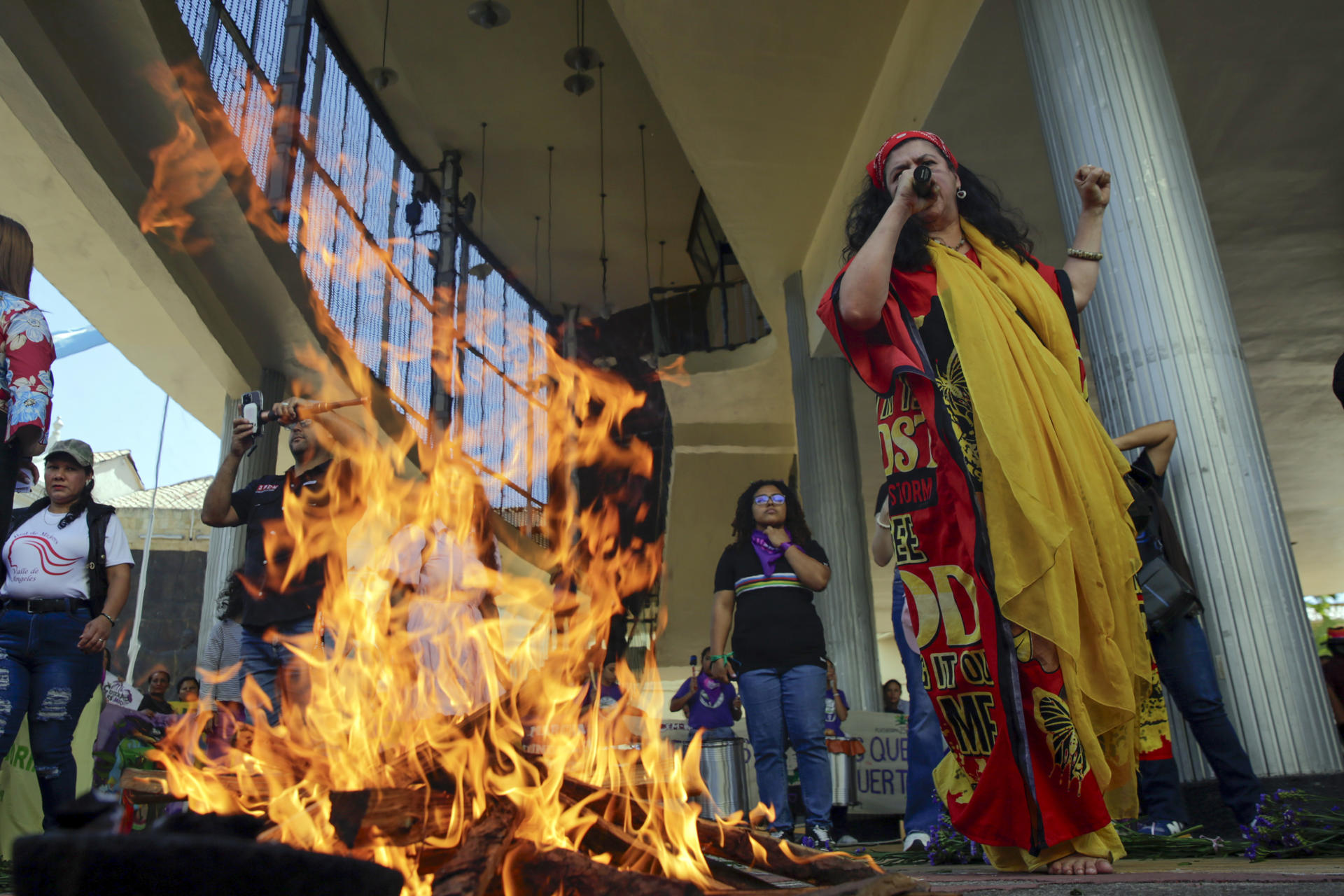 Una mujer habla junto a una fogata durante una manifestación en el marco del Día Internacional de la Mujer este viernes, frente al Parlamento en Tegucigalpa (Honduras). EFE/ Gustavo Amador