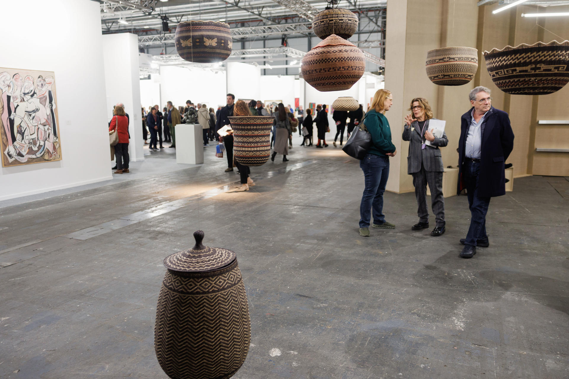Visitantes admiran la obra 'WUWA' y 'Jojo dejuco. Mamuke y tintes vegetales' de Dawa García en el Espacio Amazonia este miércoles en la 44 edición de la Feria de arte contemporáneo Arcomadrid, en la capital española. Arcomadrid se celebra del 5 al 9 de Marzo en el recinto ferial Ifema de la capital. EFE/Sergio Pérez