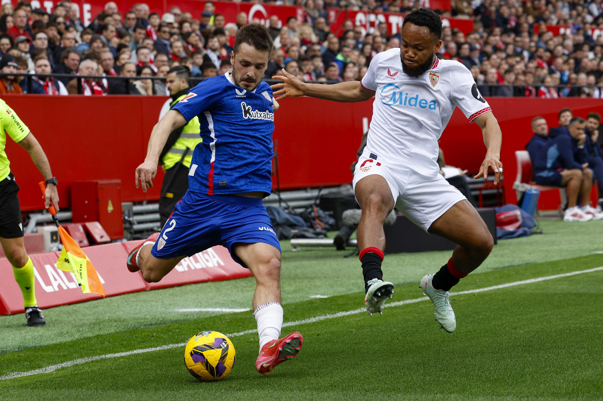 El delantero nigeriano del Sevilla Chidera Ejuke (d) pelea un balón con el defensa del Athletic Andoni Gorosabel, durante el partido de LaLiga entre el Sevilla y el Athletic Club, este domingo en el estadio Ramón Sánchez Pizjuán. EFE/ Julio Muñoz