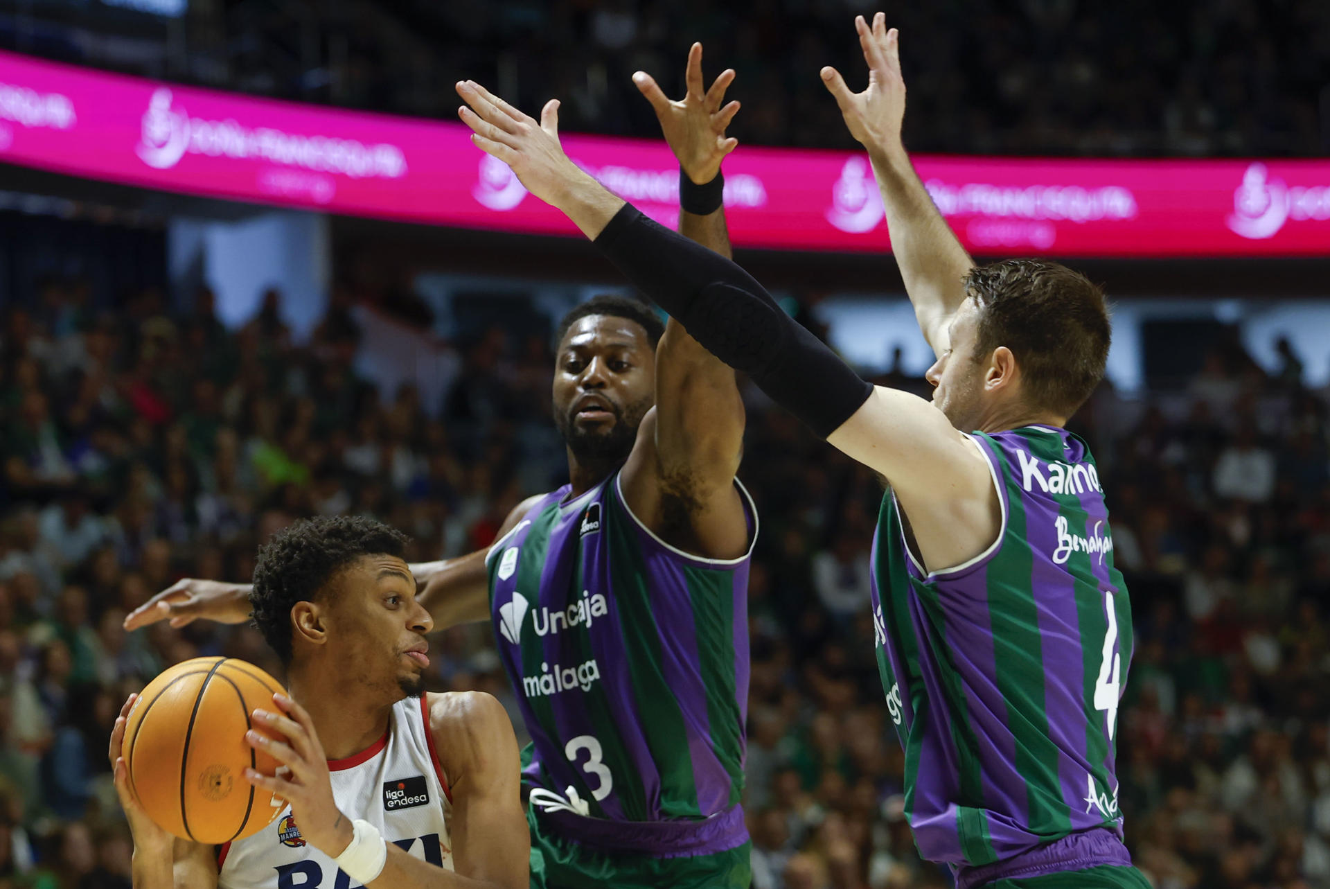 El jugador del Baxi Manresa Derrick Alston Jr. (i) defiende el balón ante los jugadores del Unicaja Melvin Ejim (c) y Tyler Kalinoski (d) en acción durante el encuentro entre el Unicaja y el Baxi Manresa disputado este domingo en el palacio de Deportes José Martín Carpena en Málaga, correspondiente a la jornada 21 de la Liga Endesa. EFE/ Jorge Zapata