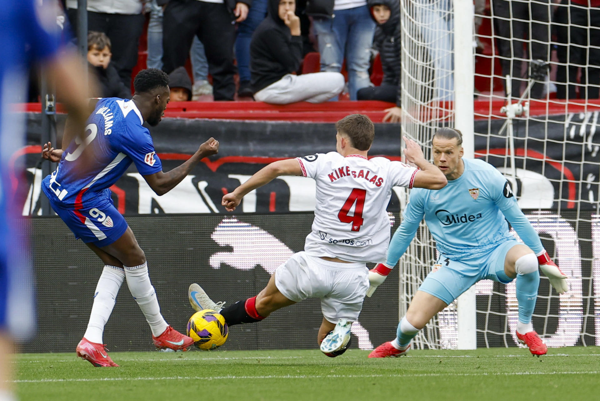 El delantero del Athletic Iñaki Williams (i) intenta un lanzamiento durante el partido de LaLiga entre el Sevilla y el Athletic Club, este domingo en el estadio Ramón Sánchez Pizjuán. EFE/ Julio Muñoz