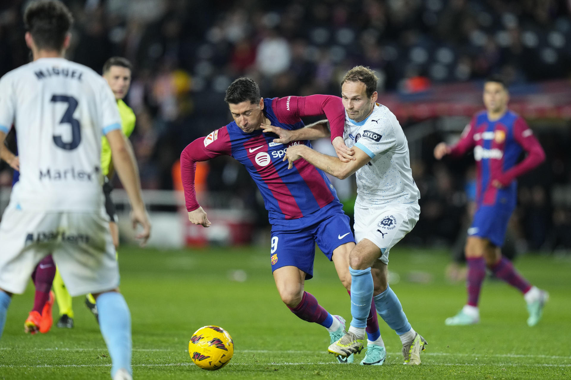 El delantero polaco del FC Barcelona, Robert Lewandowski (i), disputa el balón ante el defensa neerlandés del Girona, Daley Blind, en el estadio Olímpico Lluis Companys, en Barcelona. EFE/Siu Wu.
