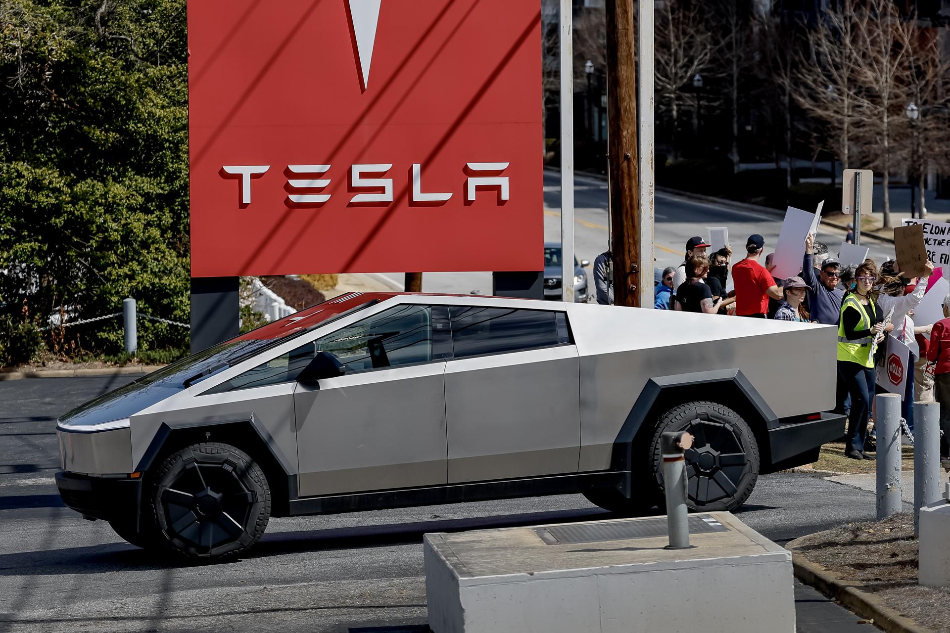 Foto de archivo que muestra una Cybertruck llega mientras manifestantes se reúnen frente a un concesionario de Tesla para protestar contra el papel actual del empresario Elon Musk en la administración del presidente de EE.UU., Donald Trump, en Decatur, Georgia, EE.UU. EFE/EPA/ERIK S. LESSER