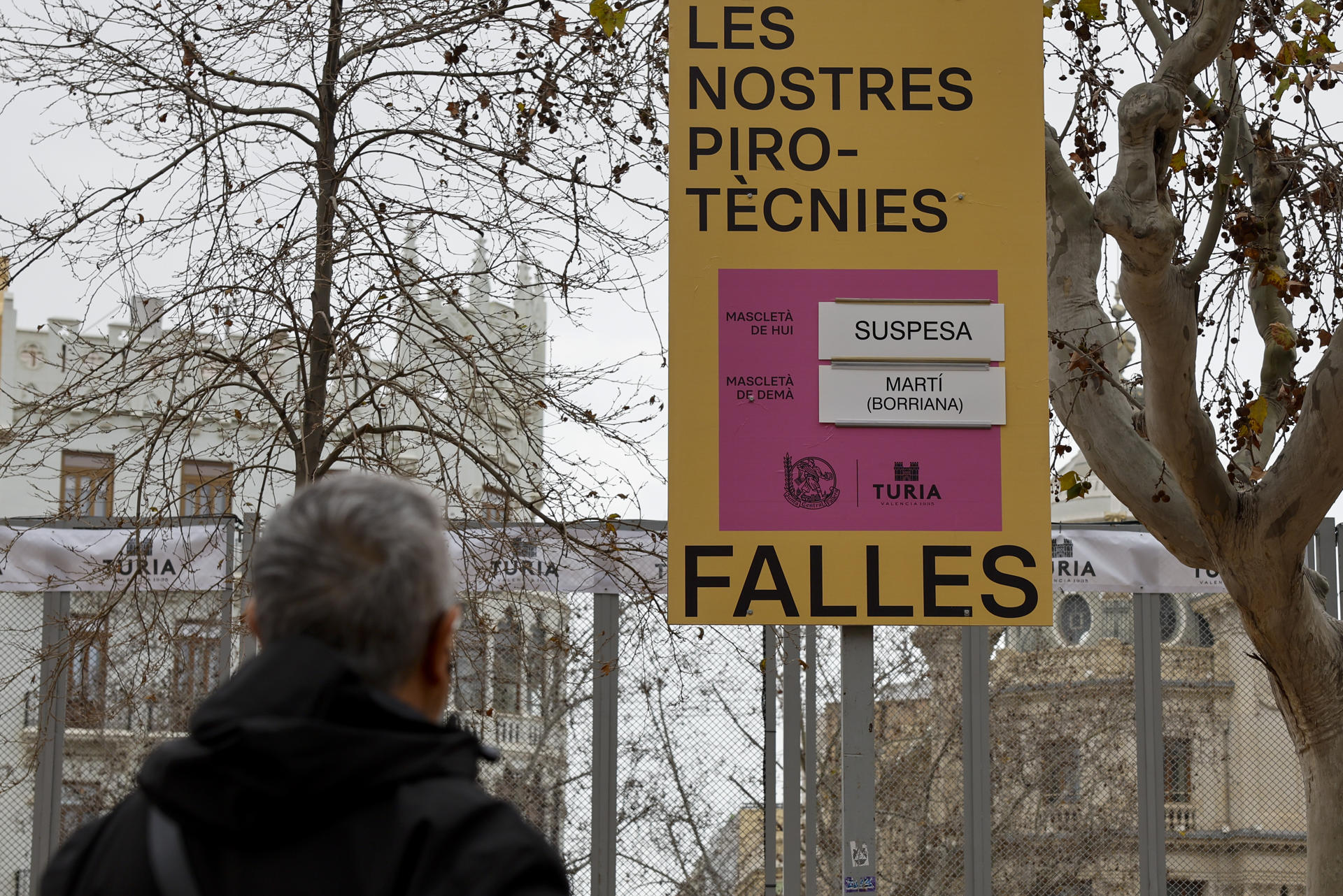 Una persona contempla el cartel que anuncia la suspensión de la mascletà durante este jueves ante la alerta meteorológica naranja en la ciudad de València. EFE/Ana Escobar