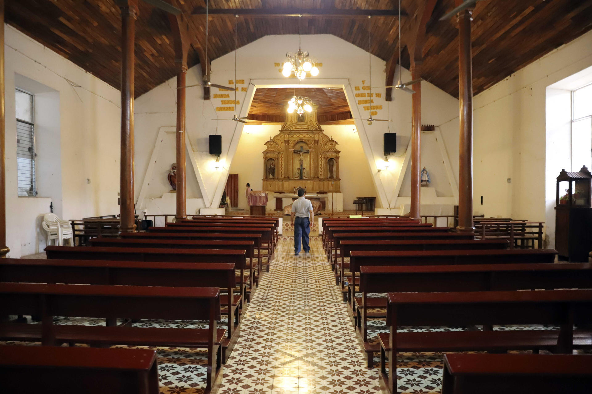 Fotografía del 6 de marzo del 2025 del párroco Mamerto Galindo mostrando los daños en las paredes de la iglesia, en el Corpus (Honduras). EFE/ Germán Reyes