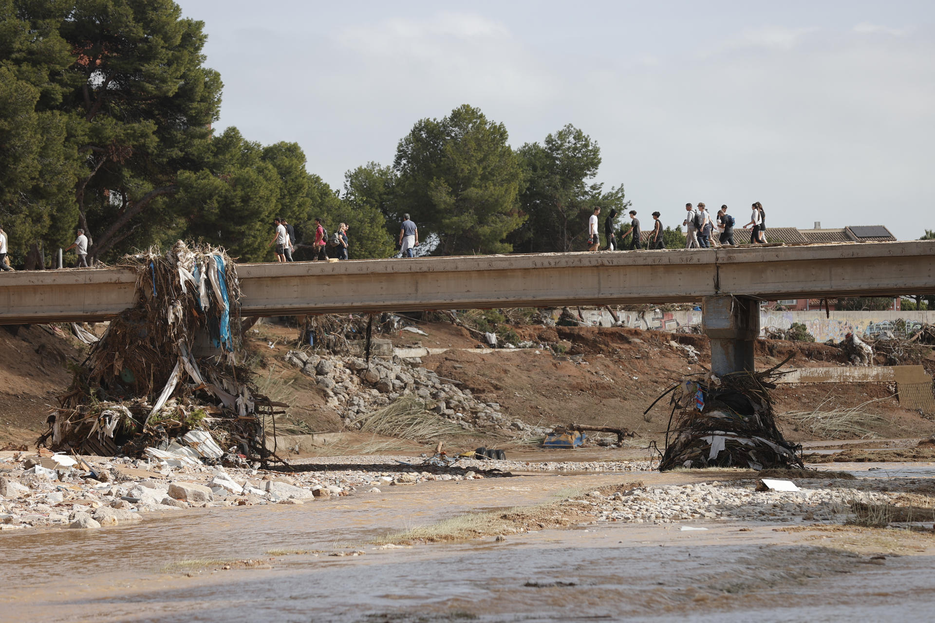 Varias personas cruzan por un puente sobre el barranco del Poyo de Paiporta, Valencia, el 31 de octubre del 2024. EFE/Manuel Bruque/Archivo