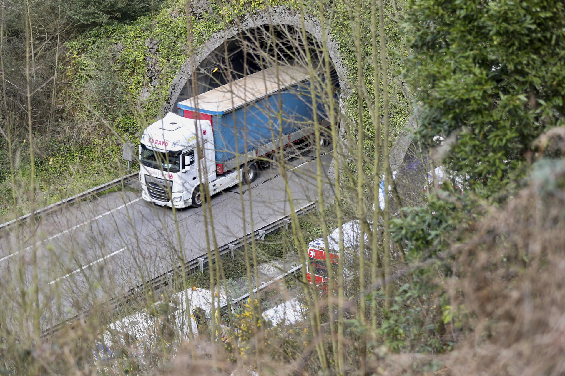 Siete personas han resultado heridas y diez vehículos se han visto involucrados al perder un camión su carga de carbón cuando circulaba por el interior del túnel de la Bolgachina, situado en la circunvalación de Oviedo, ha informado la Guardia Civil. En la imagen ambulancias a la entrada del túnel. EFE/J.L. Cereijido