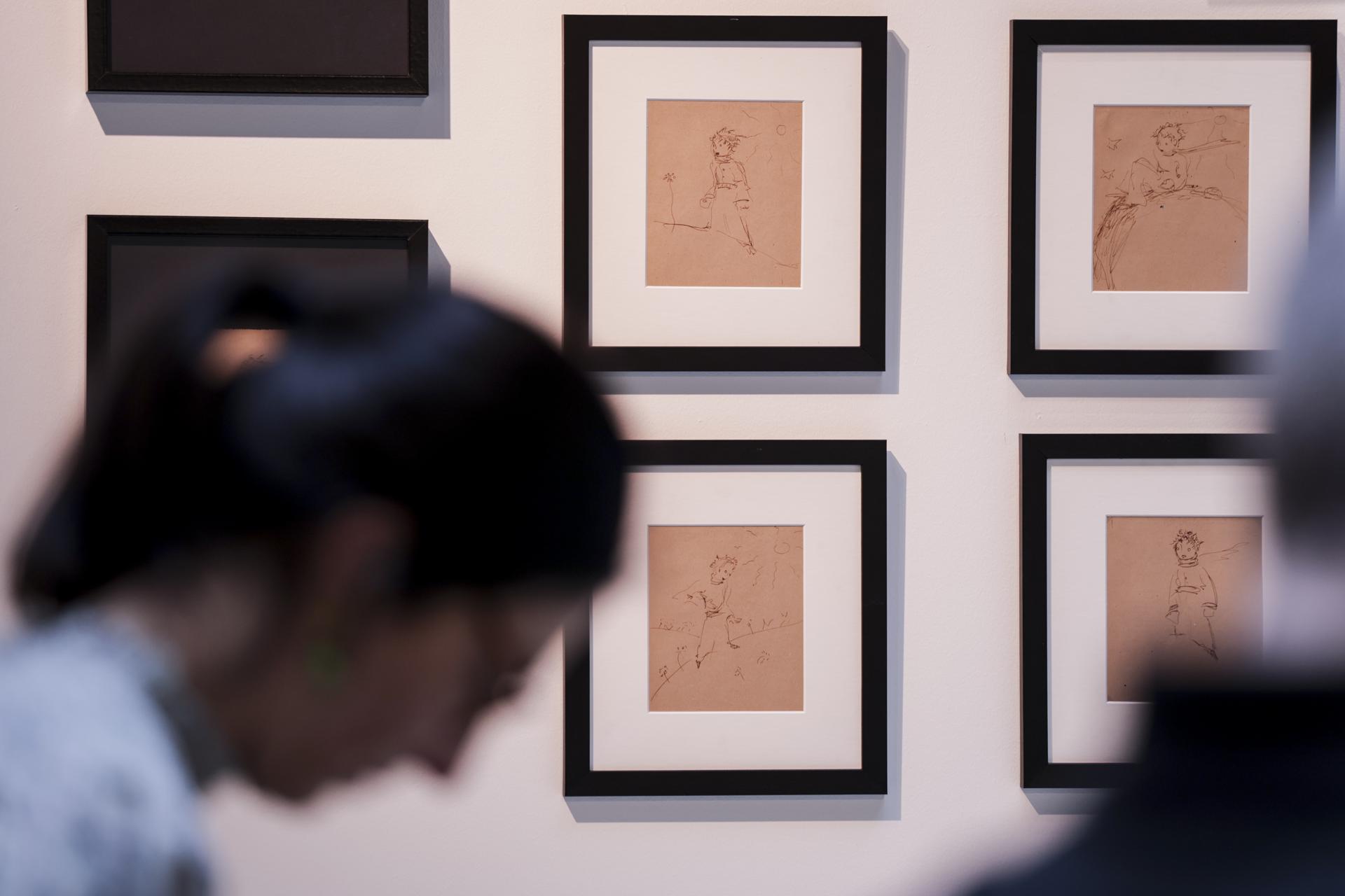 Una mujer observa parte de la colección de 16 ilustraciones originales de 1943 de El Principito de Antoine de Saint-Exupéry, exhibidas al público en Sotheby’s en París, Francia, el 25 de marzo de 2025. Ilustraciones de Antoine de Saint-Exupéry, junto con partes del manuscrito original de Aliento de Jean-Luc Godard, se subastarán entre el 04 de junio y el 18 de junio de 2025. (Francia) EFE/EPA/TERESA SUAREZ