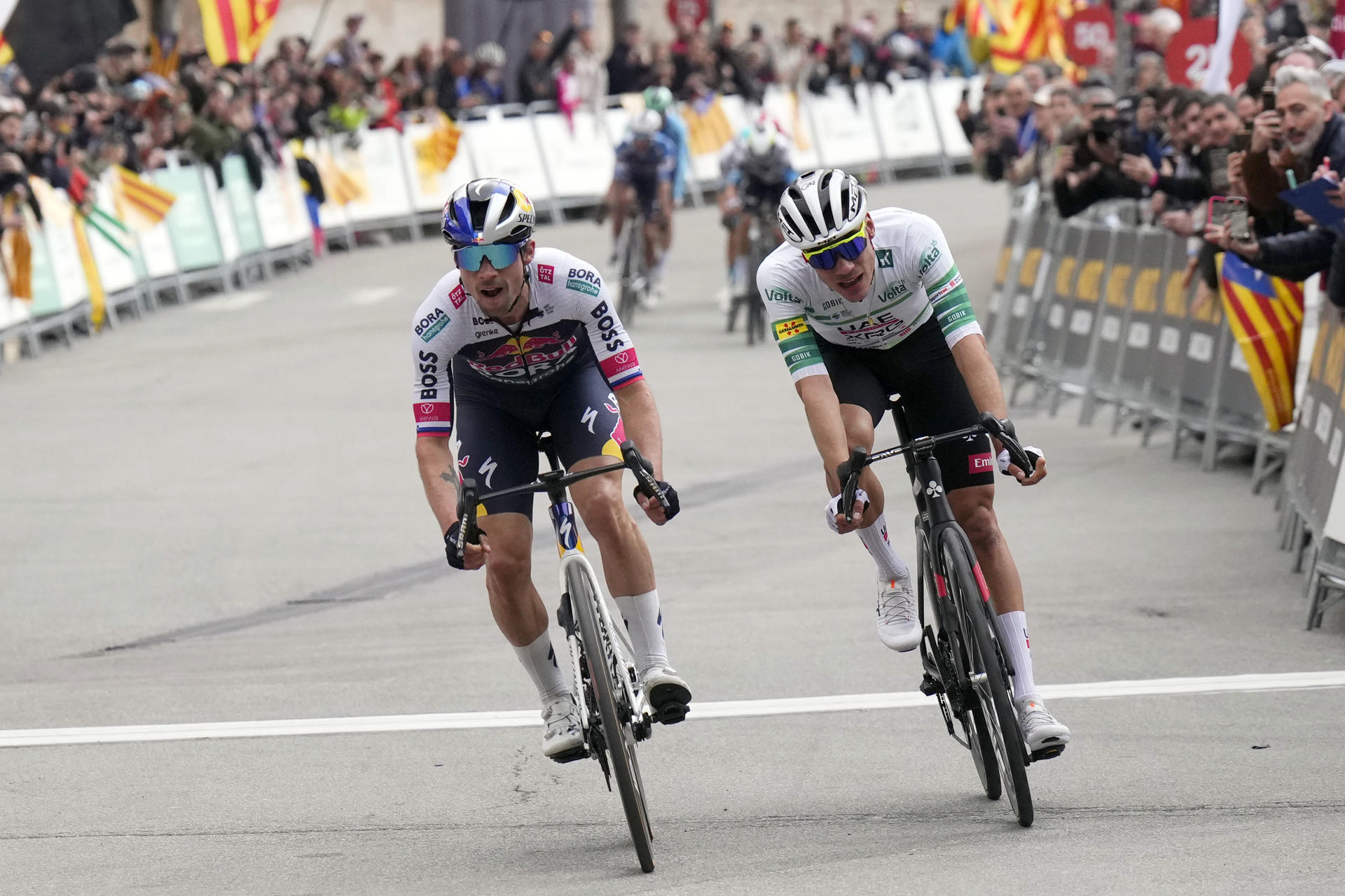 El esloveno Primoz Roglic (i) del equipo Red Bull Bora, respondió a Juan Ayuso (d), del UAE, en la cima de Montserrat, donde terminó la cuarta etapa de la Volta Ciclista a Catalunya, y se convirtió en el nuevo líder de la ronda catalana con el mismo tiempo que el ciclista español. EFE/Siu Wu