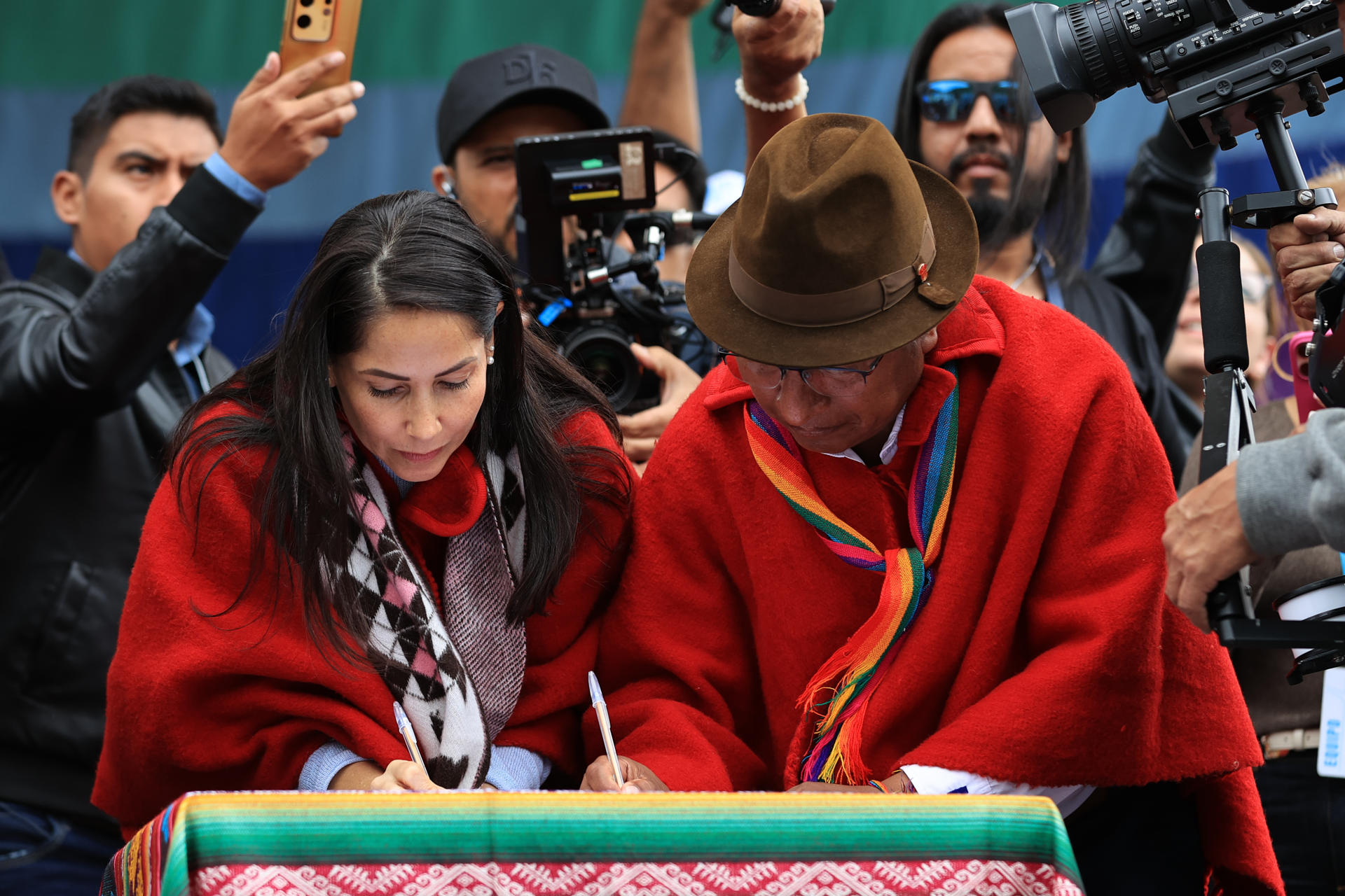 La candidata del correísmo a la Presidencia de Ecuador, Luisa González (i), firma un pacto junto al coordinador nacional del movimiento Pachakutik (PK), Guillermo Churuchumbi, este domingo, en Tixan (Ecuador). EFE/ Jose Jacome