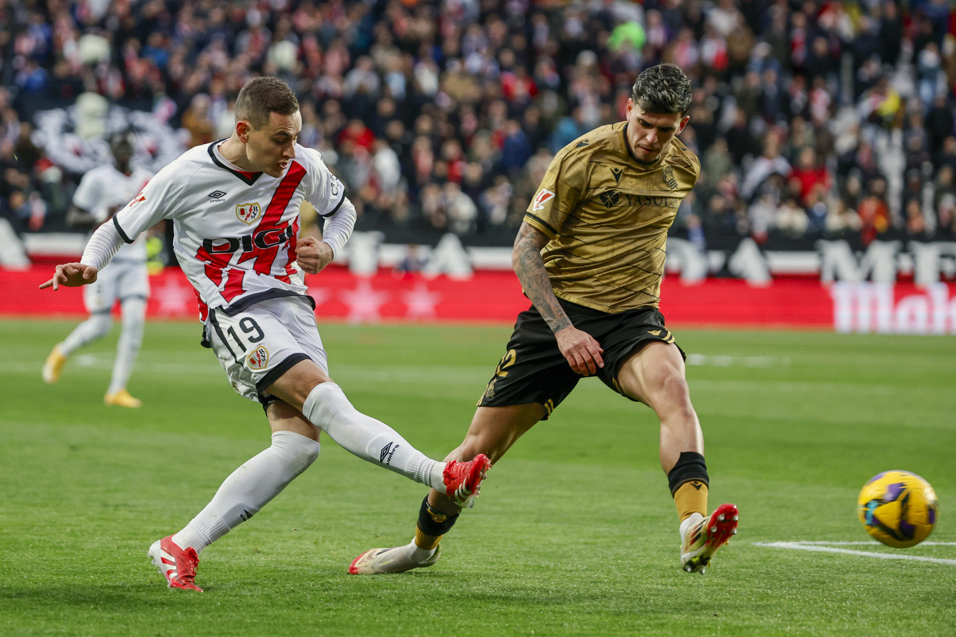 El delantero del Rayo Vallecano, Jorge de Frutos (i), golpea el balón ante el defensa de la Real Sociedad, Javi López, durante el encuentro correspondiente a la jornada 28 de Laliga EA Sportsen el estadio de Vallecas, en Madrid. EFE / Sergio Perez.