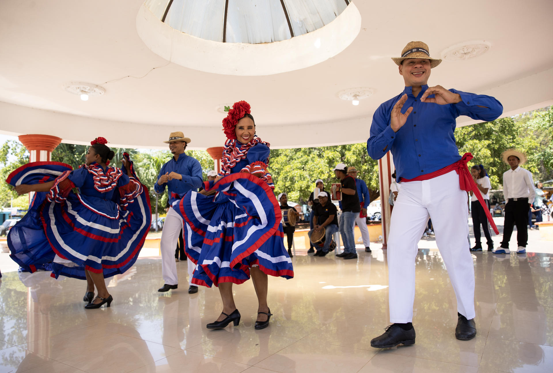 Personas con trajes típicos dan la bienvenida y bailan con turistas llegados en un crucero este martes, en Pedernales (República Dominicana). EFE/Orlando Barría