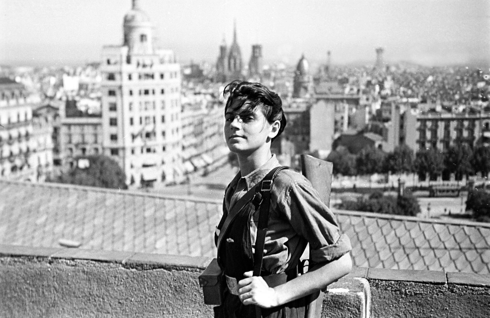 Marina Ginestà, vestida con mono de miliciana y un fusil al hombro miembro, posa en la terraza del hotel Colón de Barcelona. EFE/JUAN GUZMÁN