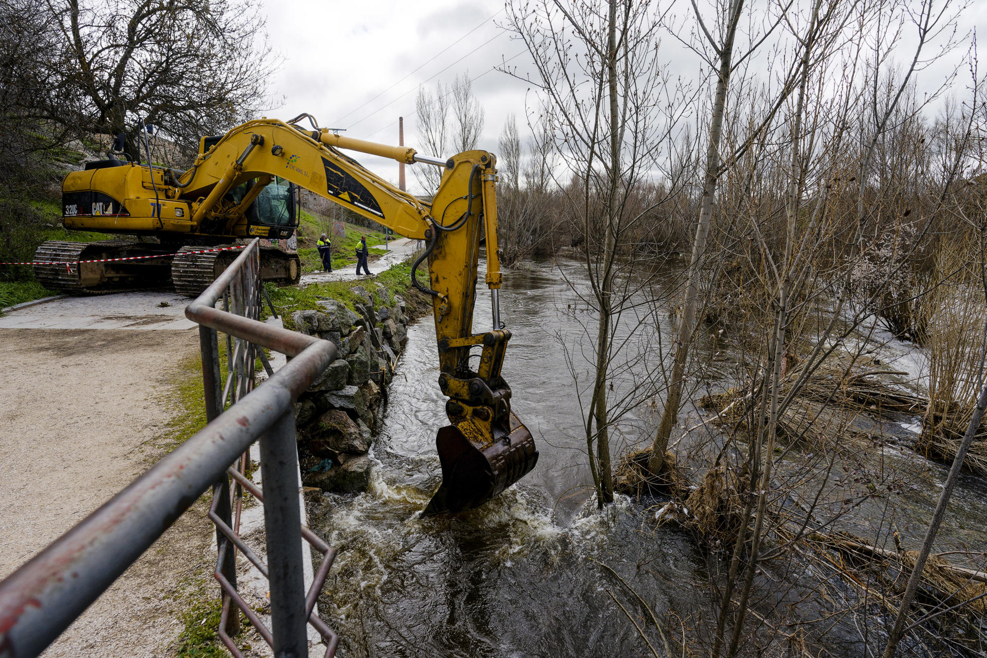 Una máquina retroexcavadora trabaja en el derribo del azud del río Adaja, a su paso por Ávila, y en labores de limpieza del cauce, este lunes. EFE/ Raúl Sanchidrián