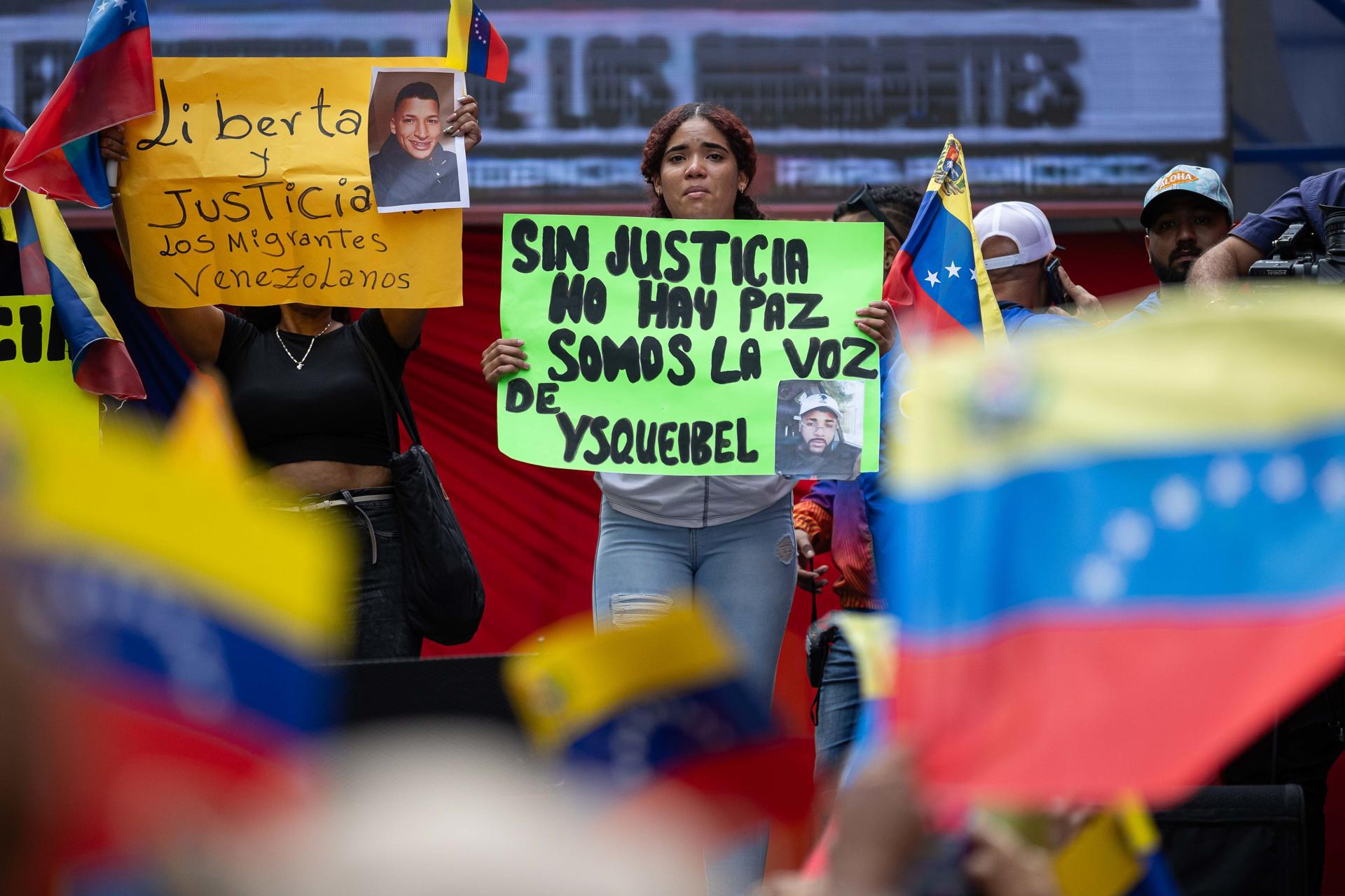 Una mujer sostiene un cartel durante una marcha oficialista en defensa de los migrantes venezolanos este martes, en Caracas (Venezuela). EFE/ Ronald Peña R