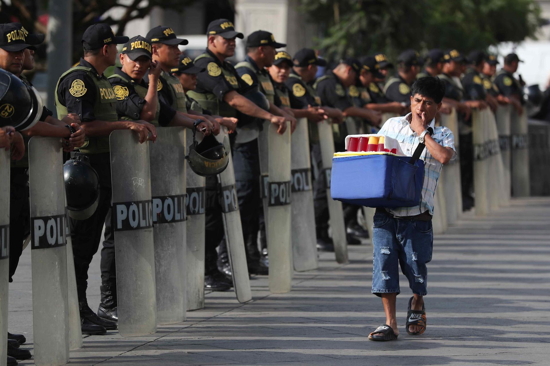Policías custodian durante una manifestación este viernes, la Plaza San Martín en Lima (Perú). Populares cantantes peruanos de grupos de cumbia y salsa se unieron a la marcha contra la inseguridad ciudadana en Lima. EFE/ Paolo Aguilar