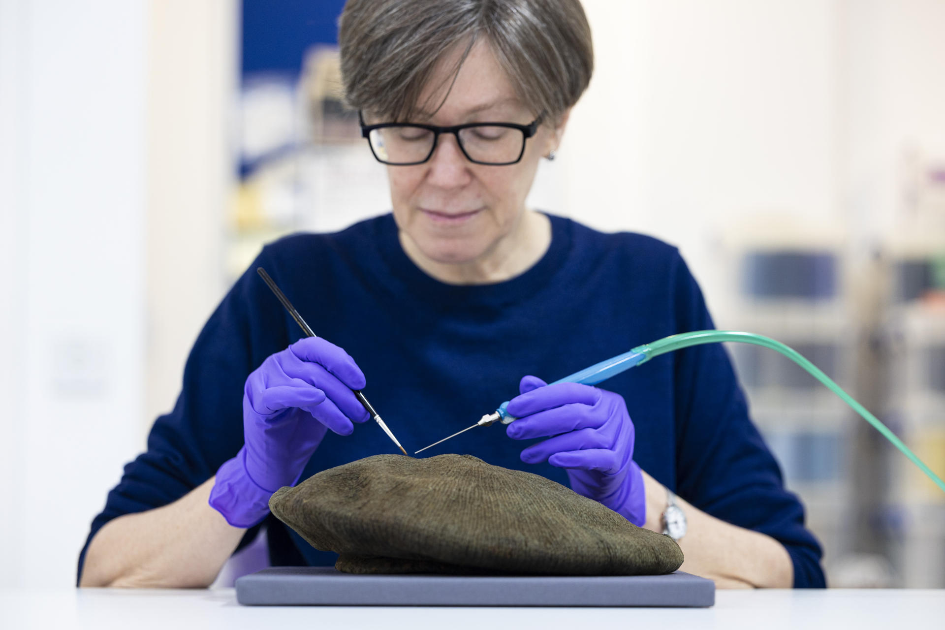 La conservadora Lynn McClean prepara la boina de lana del "Hombre de Arnish Moor", originalmente azul índigo, antes de su exhibición Una exposición en la isla escocesa de Lewis reabre el misterio sobre un asesinato ocurrido hace 250 años al exhibir la boina de lana y los objetos personales de un joven con educación académica cuyo cuerpo fue encontrado en una turbera en 1964. EFE/ National Museums Scotland SOLO USO EDITORIAL/SOLO DISPONIBLE PARA ILUSTRAR LA NOTICIA QUE ACOMPAÑA (CRÉDITO OBLIGATORIO)