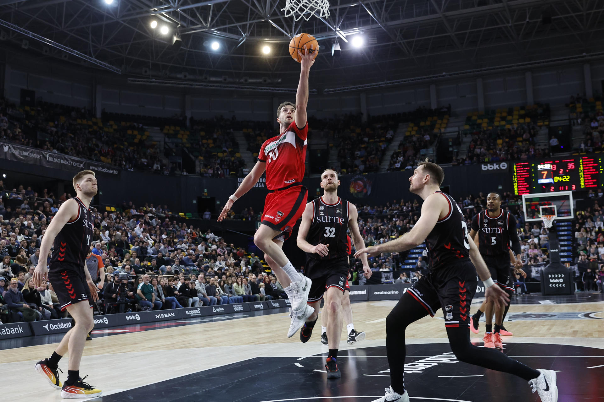 El base del Granada Sergi Garcia (c-i) entra a canasta ante los jugadores del Bilbao Basket Tryggvi Hlinason (c) y Zoran Dragic (d) durante el partido de la Liga ACB Endesa disputado este domingo en el Bilbao Arena. EFE/Miguel Toña