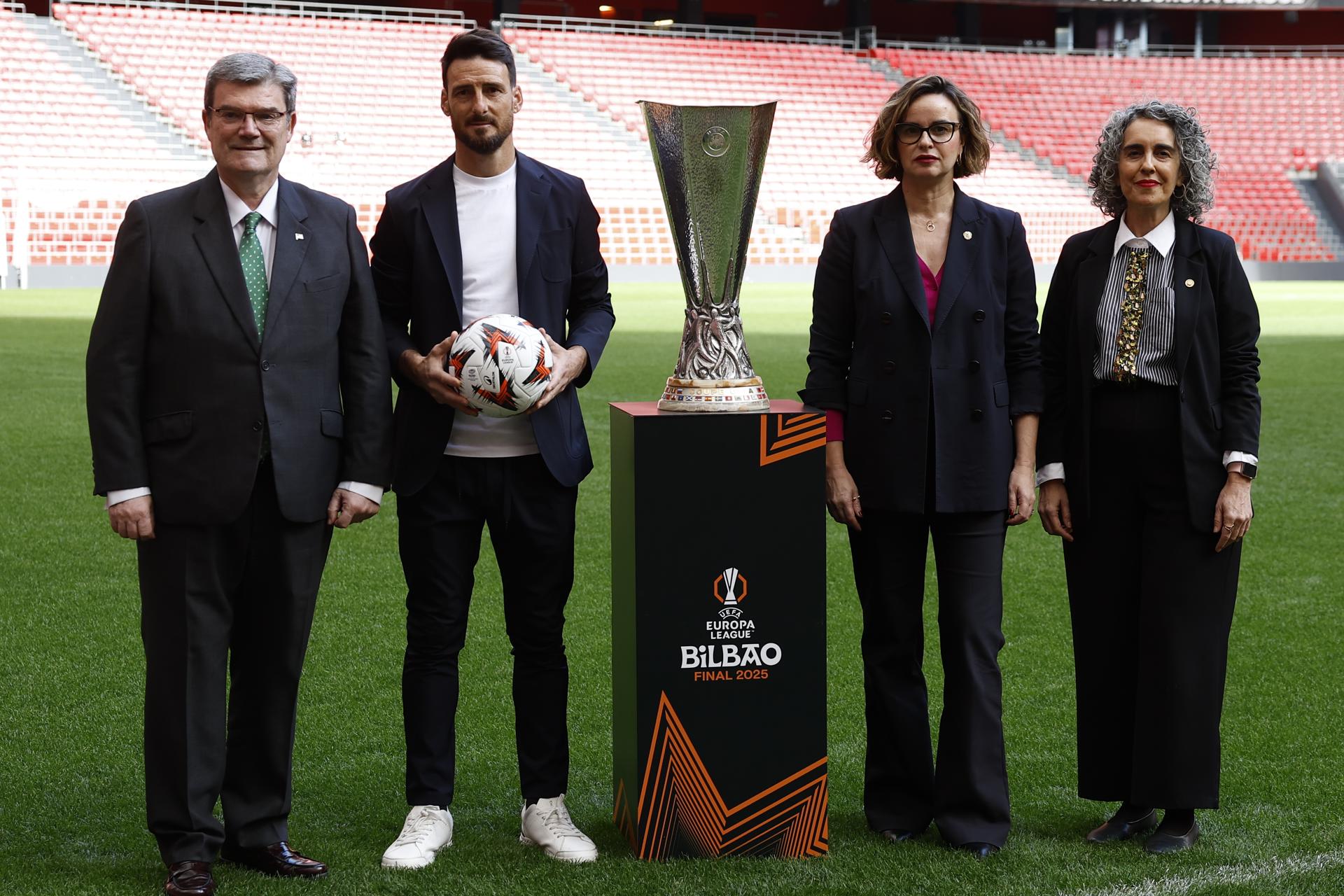 La consejera de Cultura del Gobierno Vasco, Ibone Bengoetxea (d); la diputada general de Bizkaia, Elixabete Etxanobe (2d), el alcalde de Bilbao, Juan Mari Aburto (i), y el embajador de la UEFA, Aritz Aduriz (2i), han presentado este viernes en el estadio de San Mamés la campaña para la final de la UEFA Europa League 2025 ‘Bizi beharreko Finala - Una Final de Aupa’. EFE/ Miguel Toña
