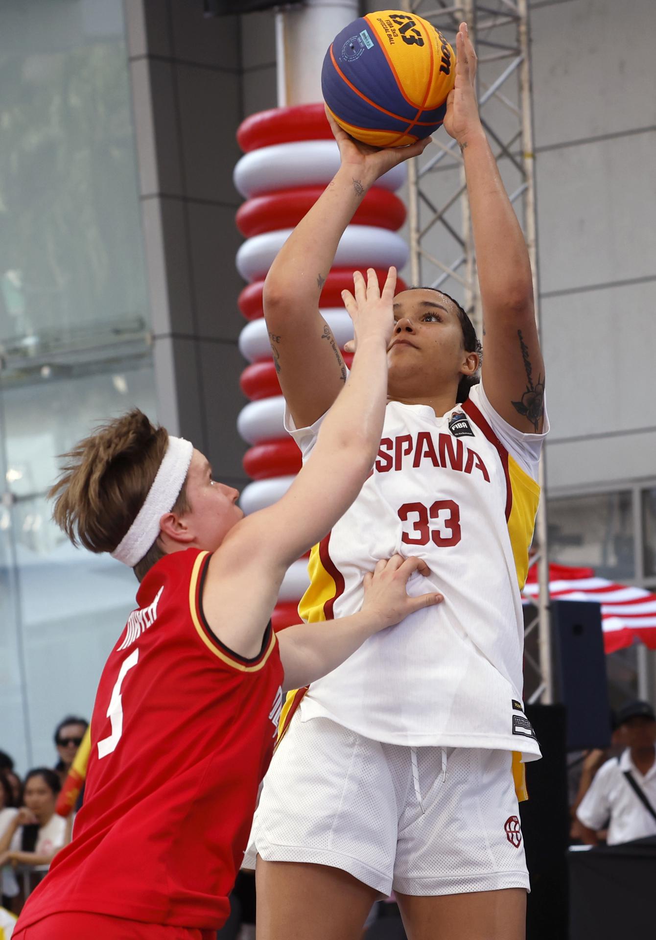 La jugadora española Cecilia Muhate (d) tira a canasta frente a la alemana Pauline Marie Mayer (i) durante la semifinal de la Copa de Campeones, que se disputa en Bangkok.
EFE/EPA/RUNGROJ YONGRIT