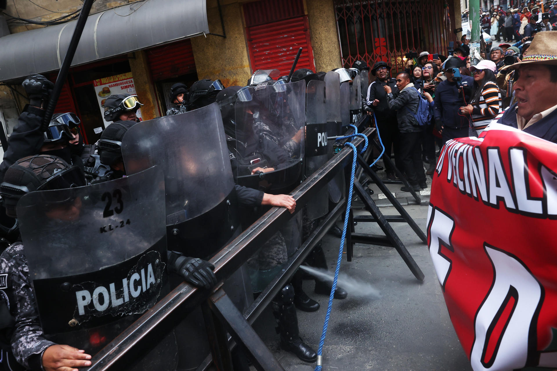 Integrantes de la policía de Bolivia y manifestantes se enfrentan durante una protesta este lunes, en La Paz (Bolivia). EFE/ Luis Gandarillas