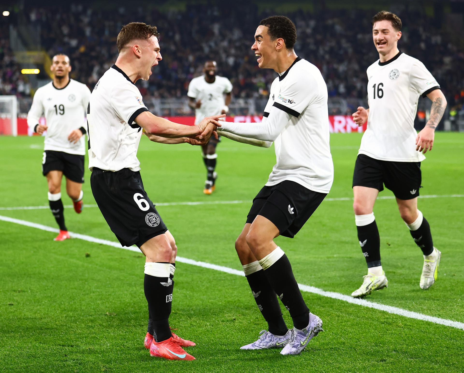 Jamal Musiala (C) y Joshua Kimmich celebran el segundo gol contra Italia, durante el partido de vuelta de los cuartos de final de la Liga de Naciones de la UEFA. EFE/EPA/CHRISTOPHER NEUNDORF