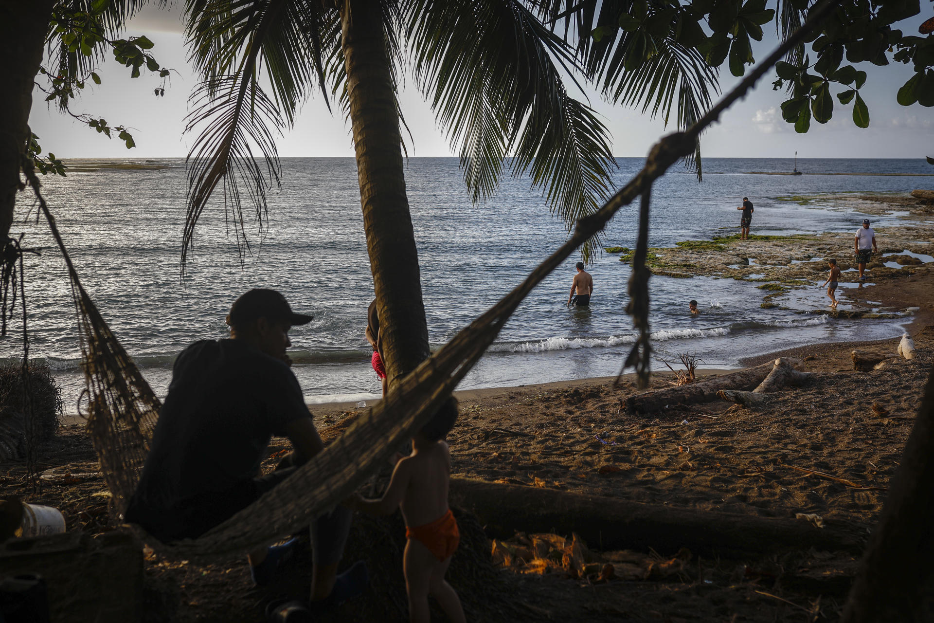 Fotografía del 8 de marzo de 2025 de migrantes venezolanos esperando en la playa del puerto de Miramar en Colón (Panamá). EFE/ Bienvenido Velasco