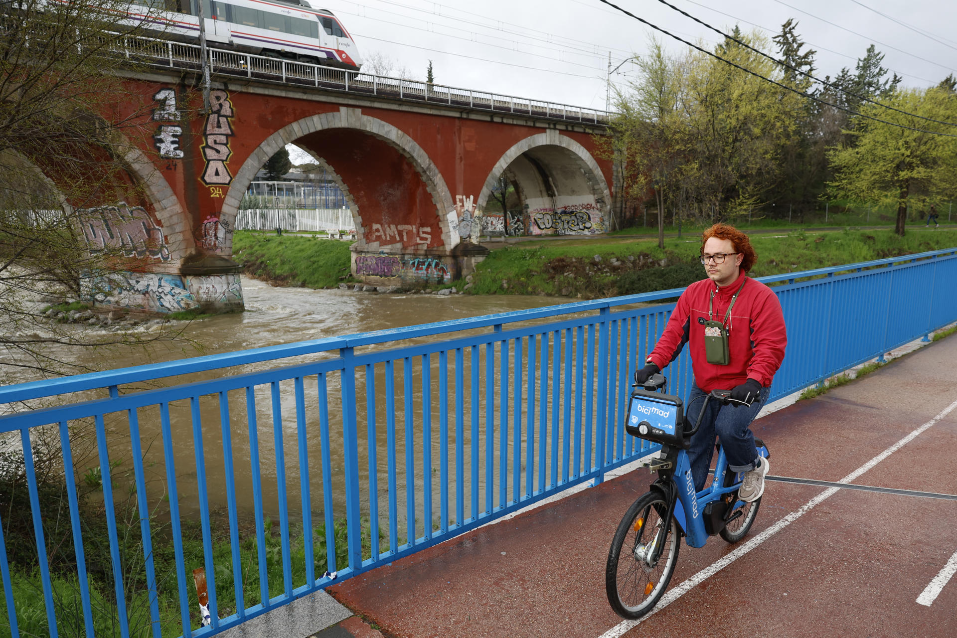 Un ciclista pasa este viernes junto al río Manzanares a la altura del puente de los franceses. Emergencias Madrid ha recomendado esta noche que se eviten los desplazamientos innecesarios, especialmente cerca de los ríos Manzanares y Jarama, ante las posibles inundaciones por las fuertes lluvias. EFE/ Mariscal